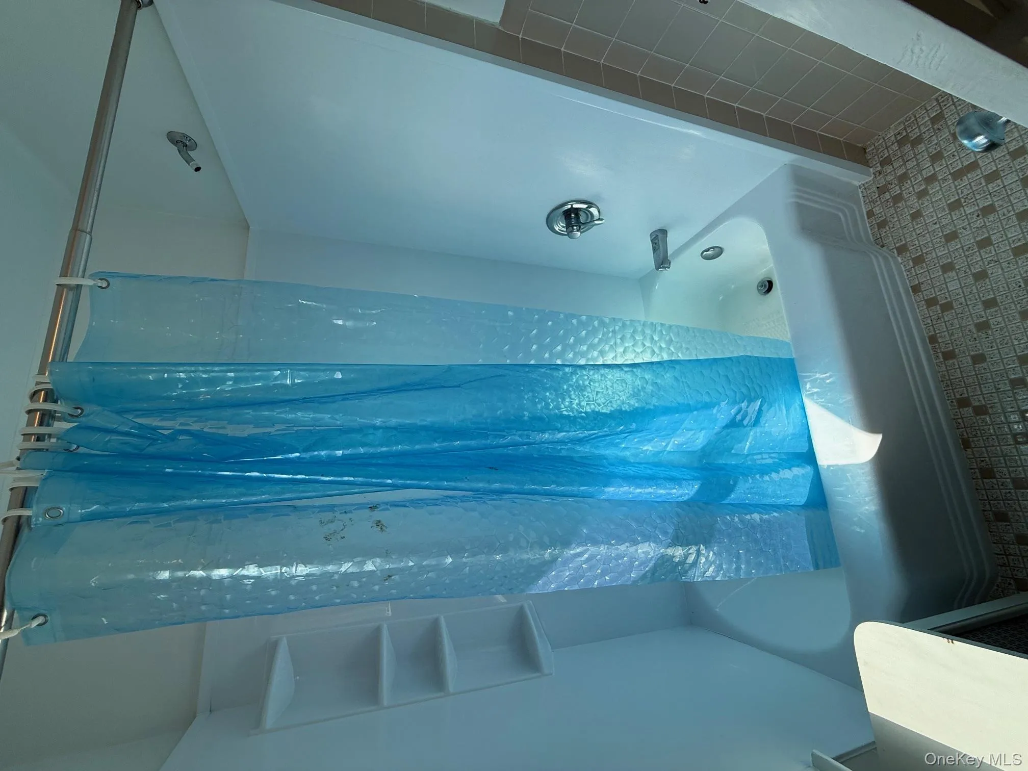 Full bathroom featuring shower / bath combo with shower curtain, vanity, and tile patterned flooring Full bathroom featuring shower / bath combo with shower curtain, vanity, and tile patterned flooring