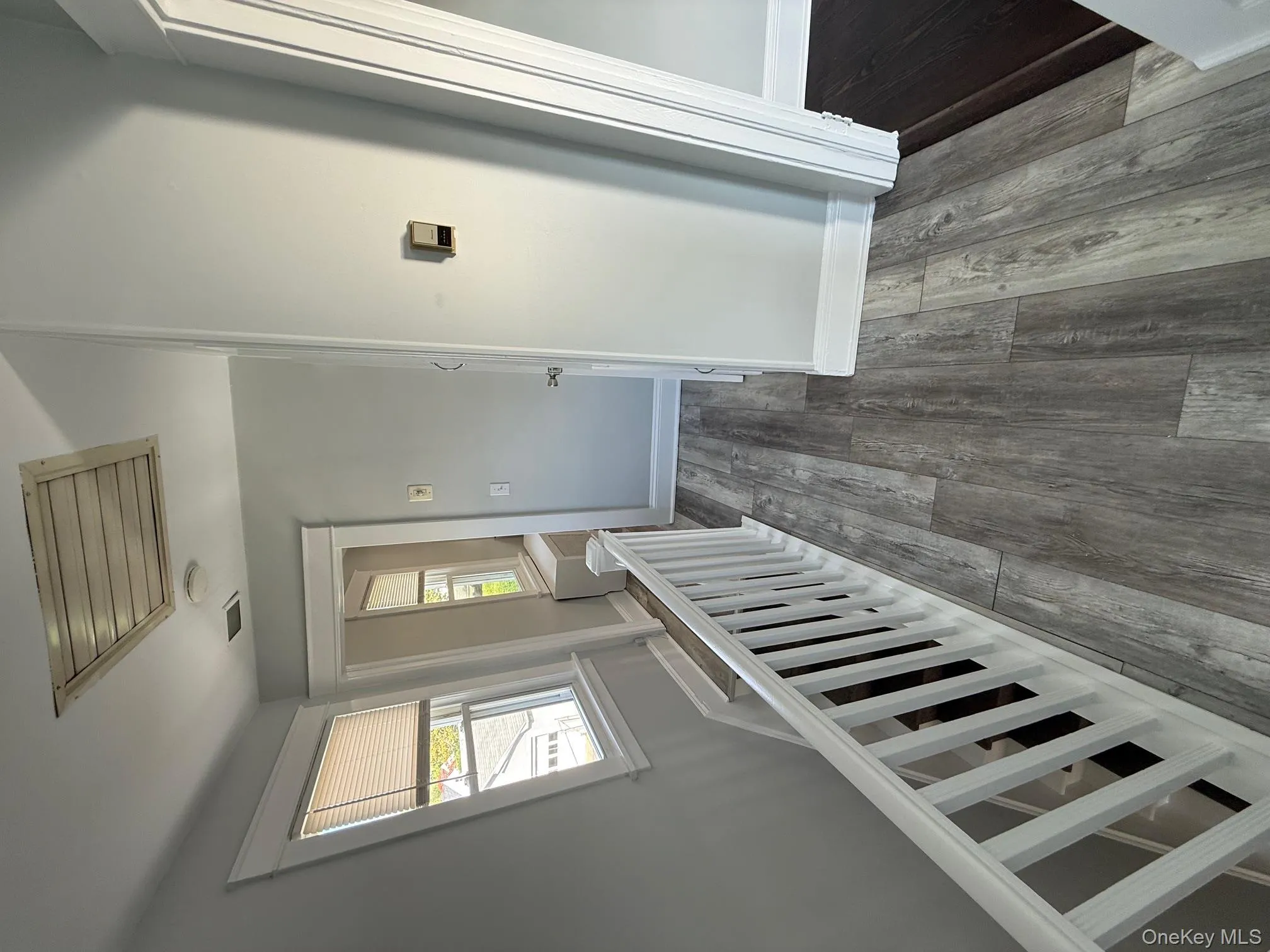 Corridor featuring an upstairs landing and dark wood-style flooring Corridor featuring an upstairs landing and dark wood-style flooring