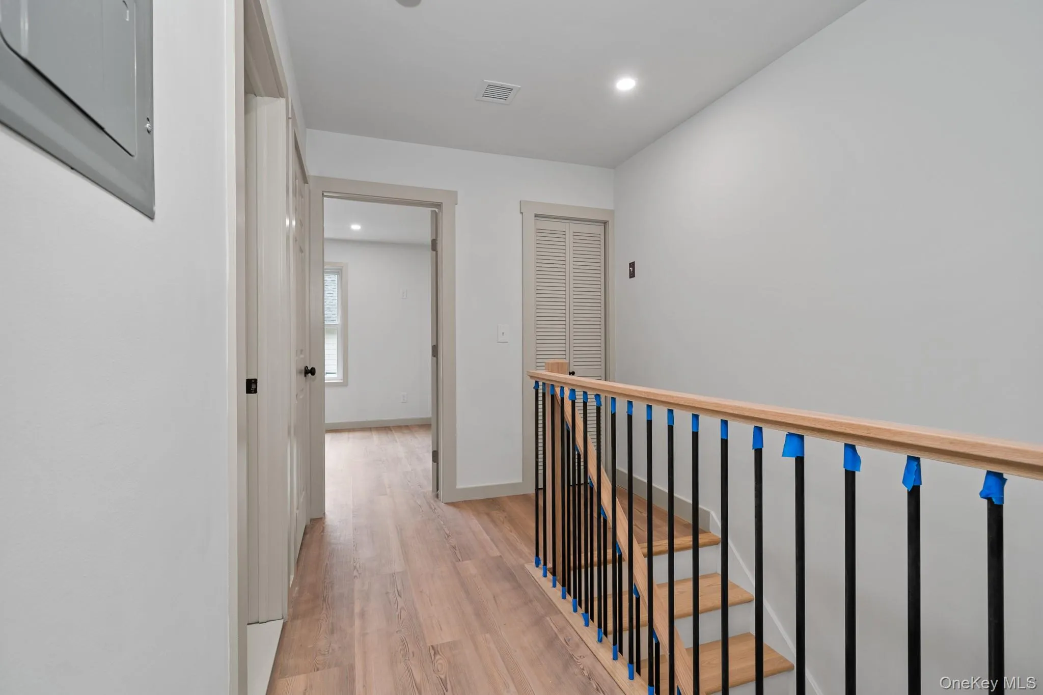 Hallway featuring recessed lighting, light wood-style floors, and electric panel Hallway featuring recessed lighting, light wood-style floors, and electric panel