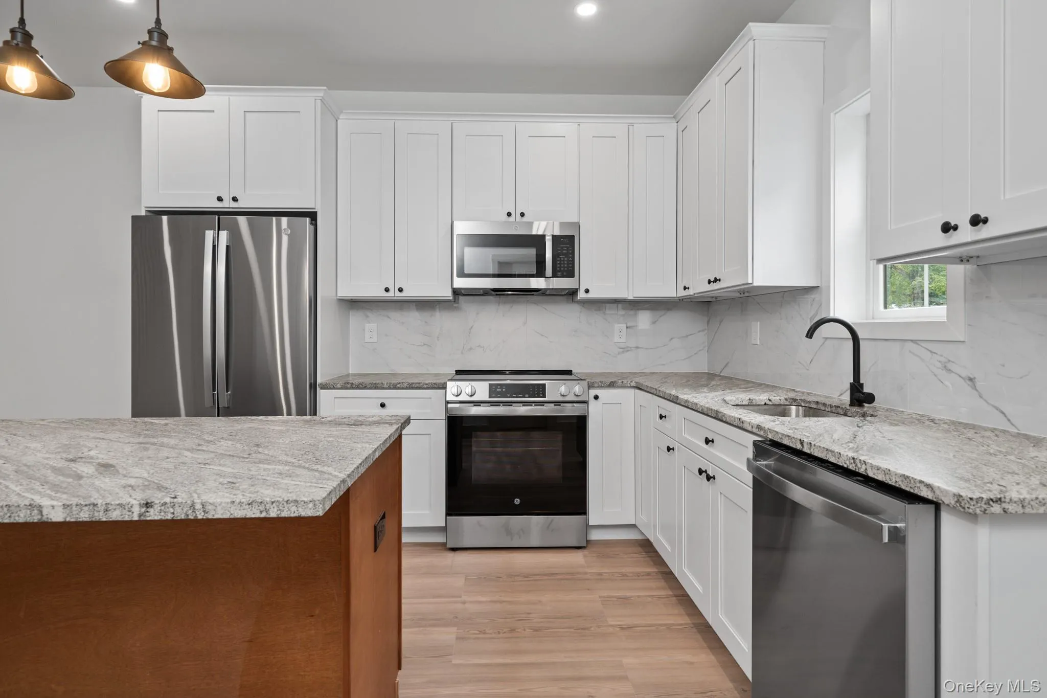 Kitchen featuring stainless steel appliances, decorative backsplash, light stone countertops, and recessed lighting Kitchen featuring stainless steel appliances, decorative backsplash, light stone countertops, and recessed lighting