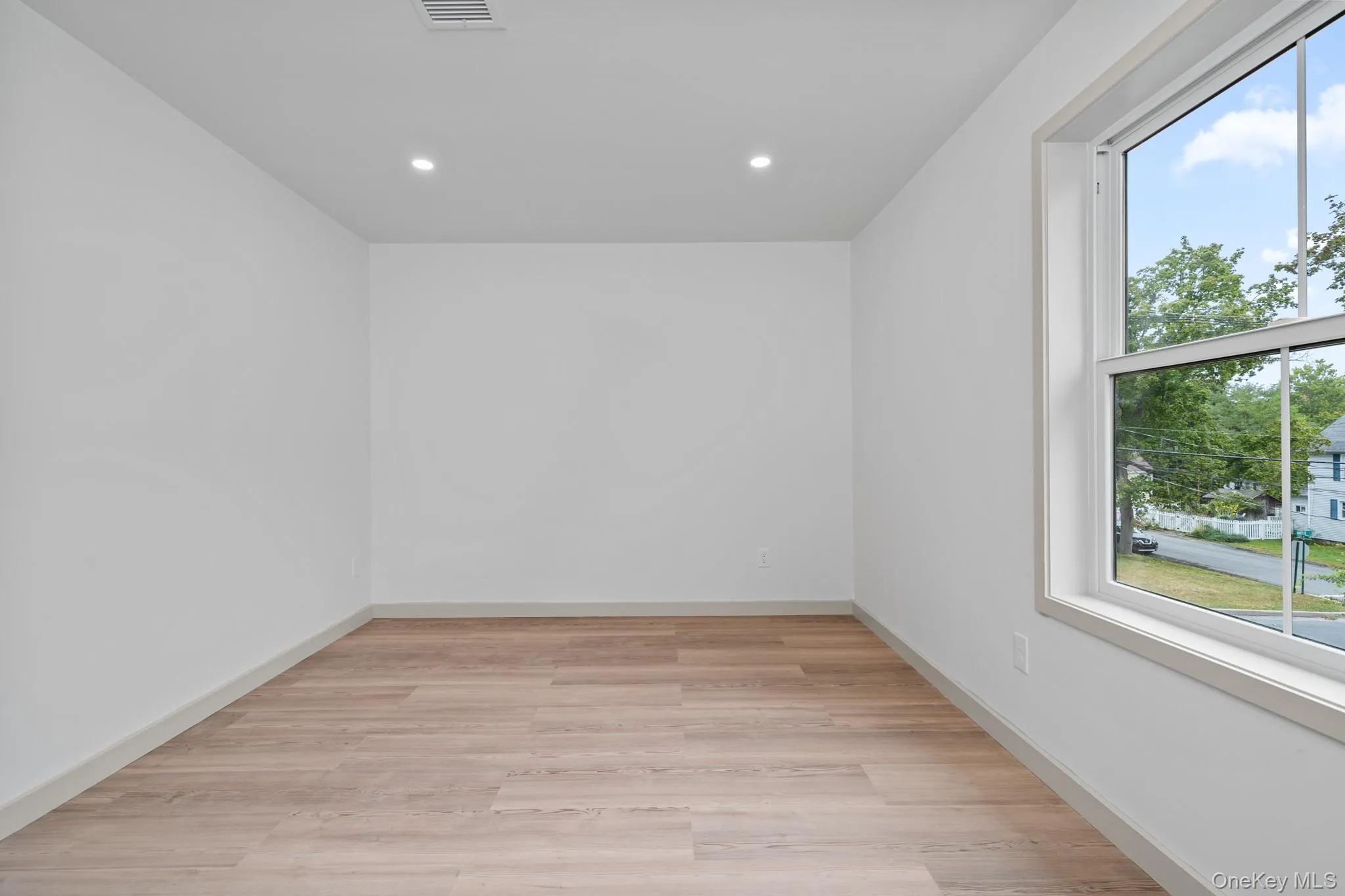 Empty room featuring light wood finished floors and recessed lighting Empty room featuring light wood finished floors and recessed lighting