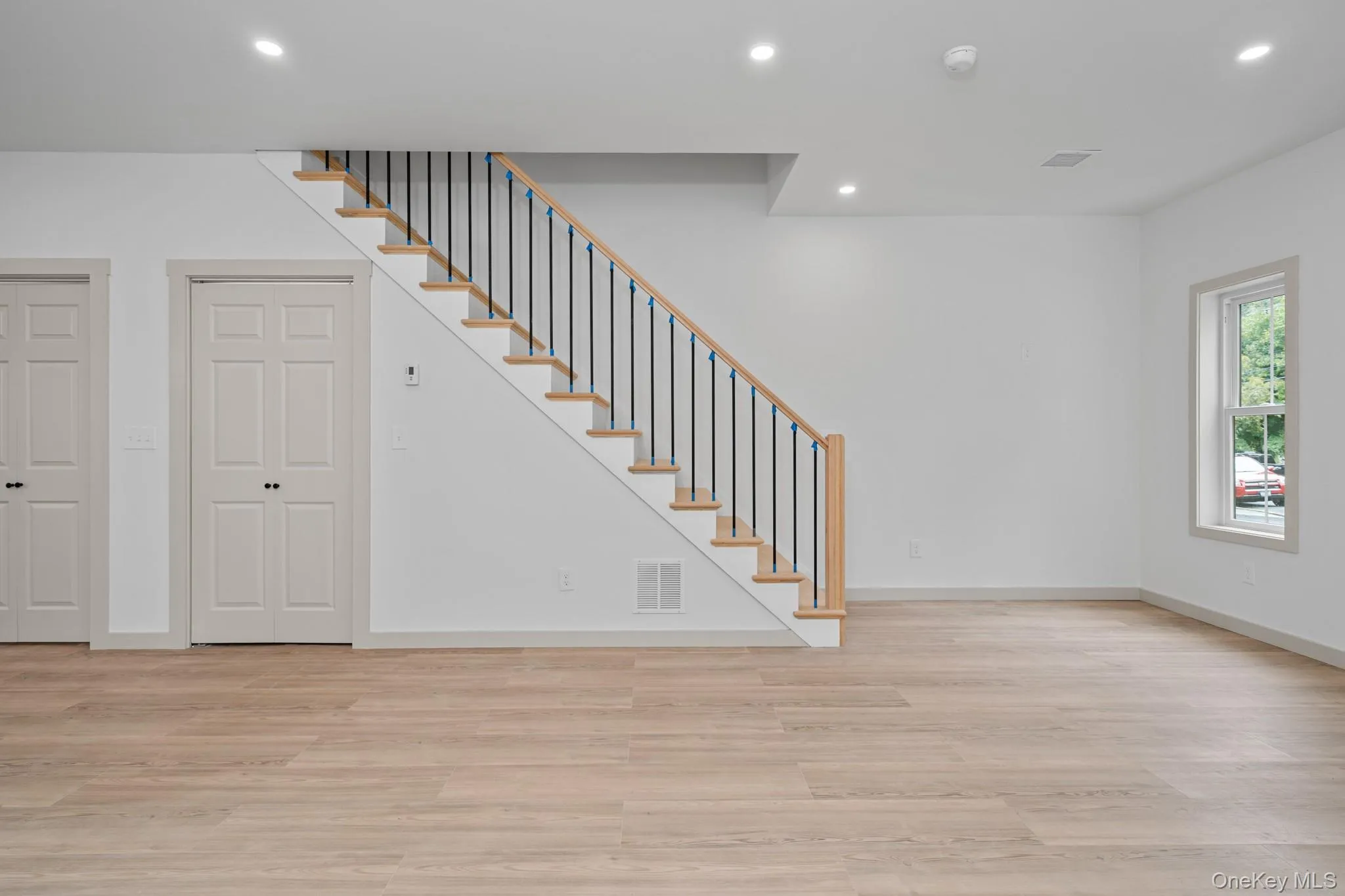 Below grade area featuring recessed lighting, light wood-style floors, and stairway Below grade area featuring recessed lighting, light wood-style floors, and stairway