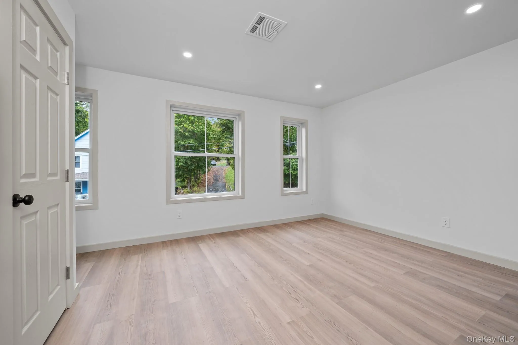 Empty room with light wood finished floors and recessed lighting Empty room with light wood finished floors and recessed lighting