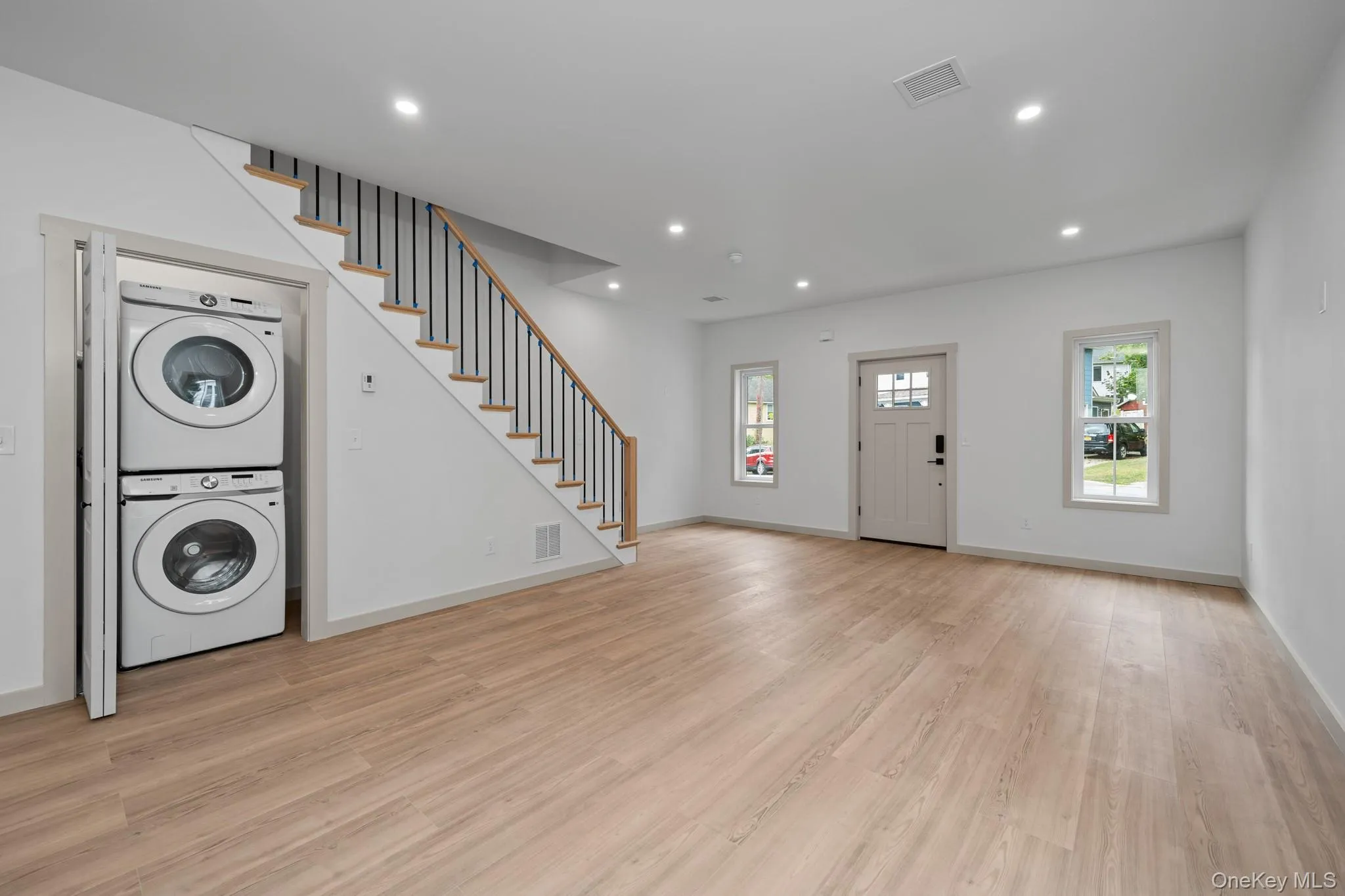 Foyer featuring recessed lighting, light wood-type flooring, stairway, and stacked washer / drying machine Foyer featuring recessed lighting, light wood-type flooring, stairway, and stacked washer / drying machine