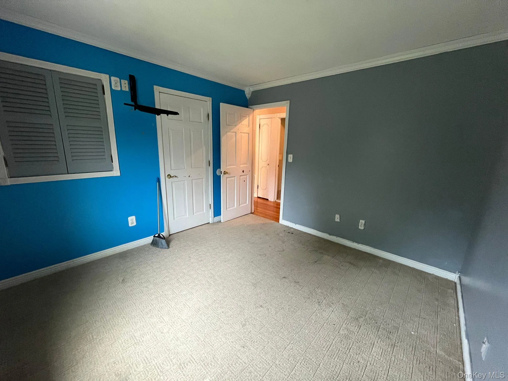 Unfurnished bedroom featuring ornamental molding, carpet floors, and a closet Unfurnished bedroom featuring ornamental molding, carpet floors, and a closet