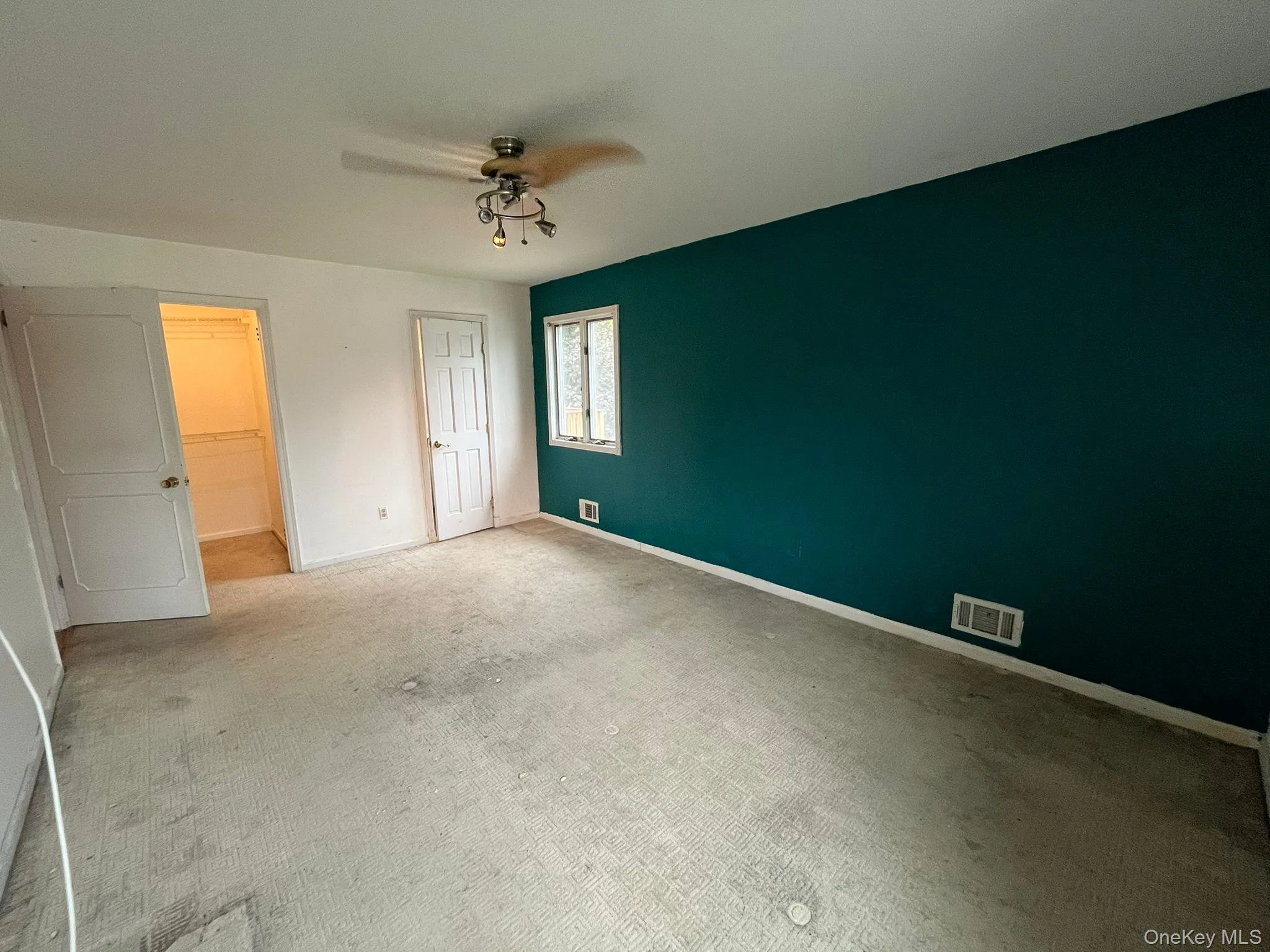 Unfurnished bedroom featuring carpet, ceiling fan, and a spacious closet Unfurnished bedroom featuring carpet, ceiling fan, and a spacious closet