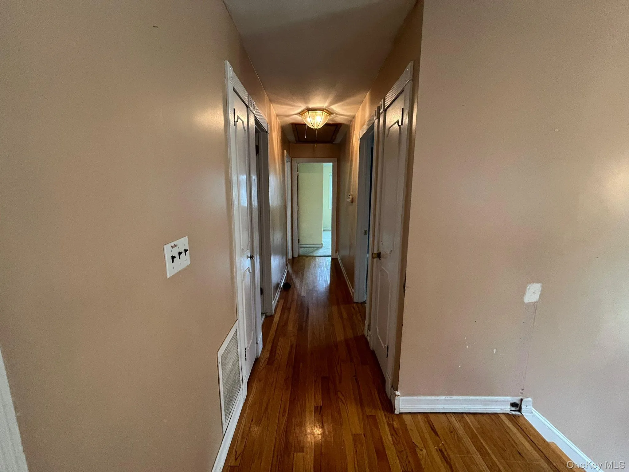 Hallway with attic access and wood finished floors Hallway with attic access and wood finished floors