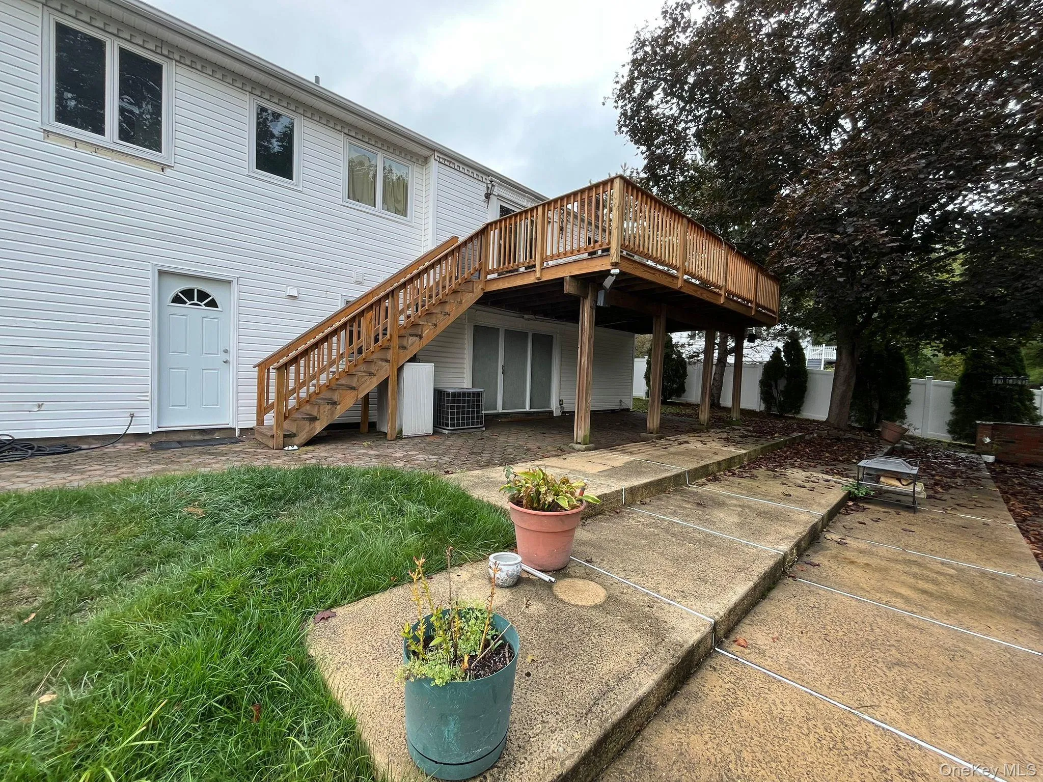 Back of property featuring a wooden deck, stairway, and a patio area Back of property featuring a wooden deck, stairway, and a patio area
