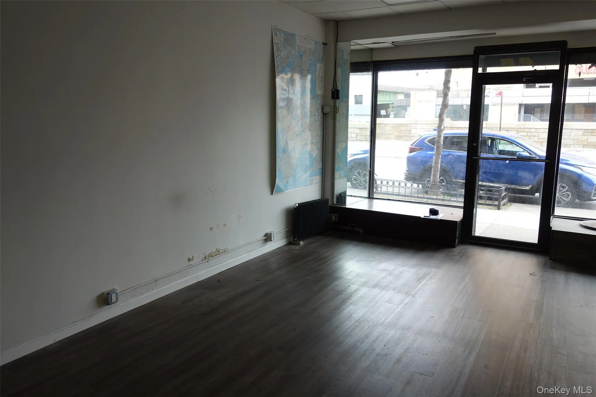 Spare room with dark wood-style flooring and radiator Spare room with dark wood-style flooring and radiator