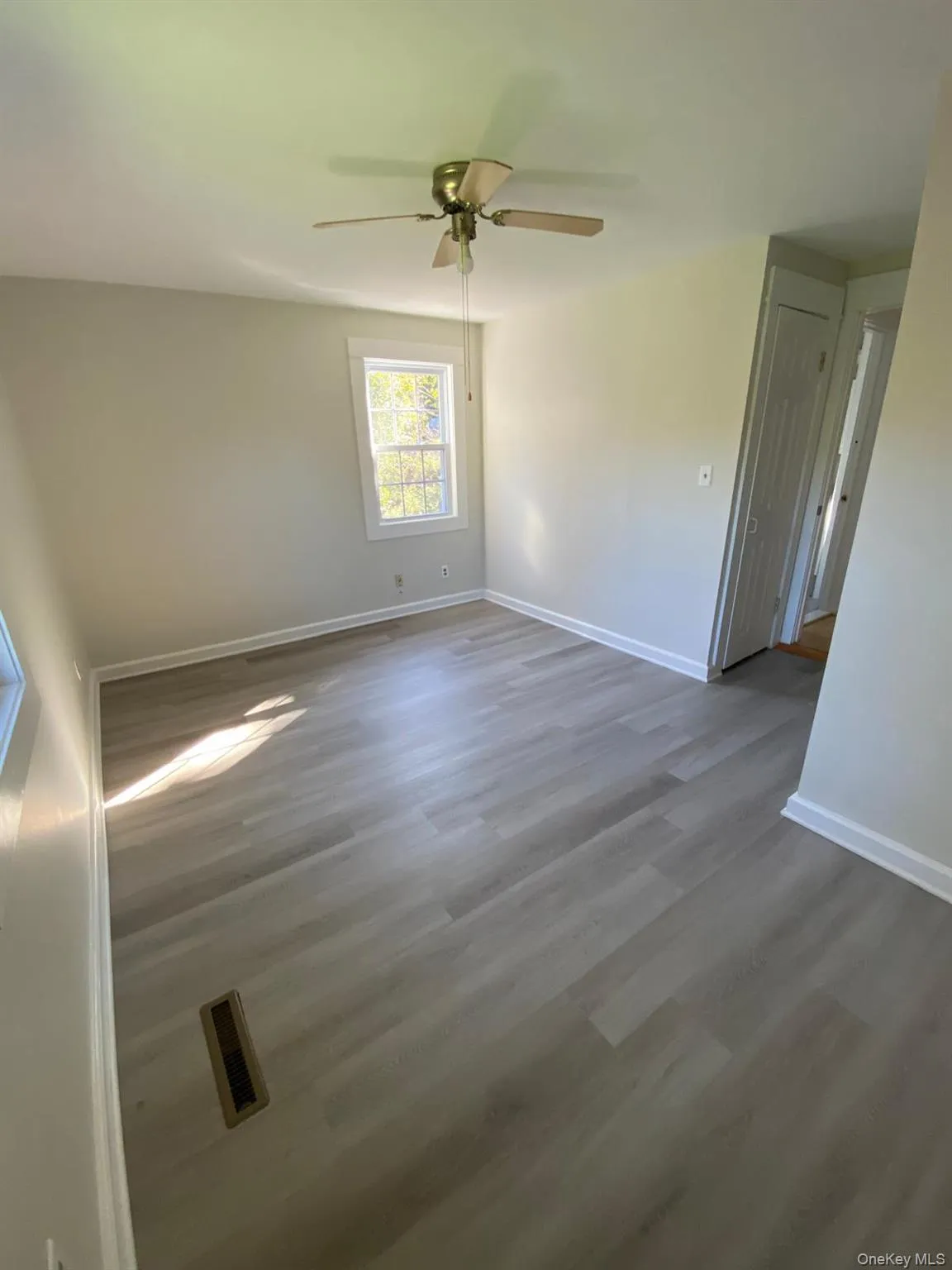 Unfurnished room featuring wood finished floors and a ceiling fan Unfurnished room featuring wood finished floors and a ceiling fan