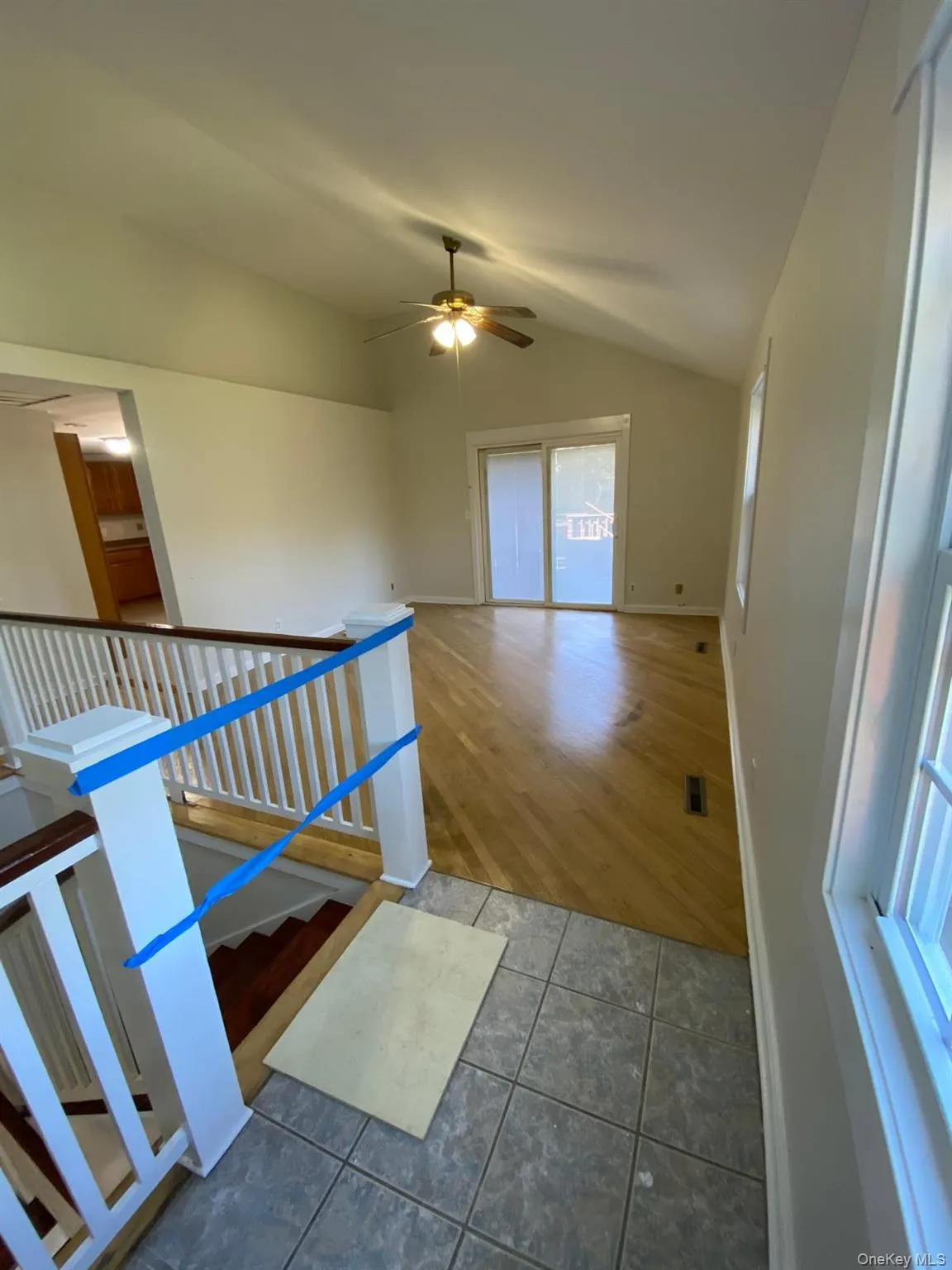 Stairway featuring wood finished floors, vaulted ceiling, and a ceiling fan Stairway featuring wood finished floors, vaulted ceiling, and a ceiling fan