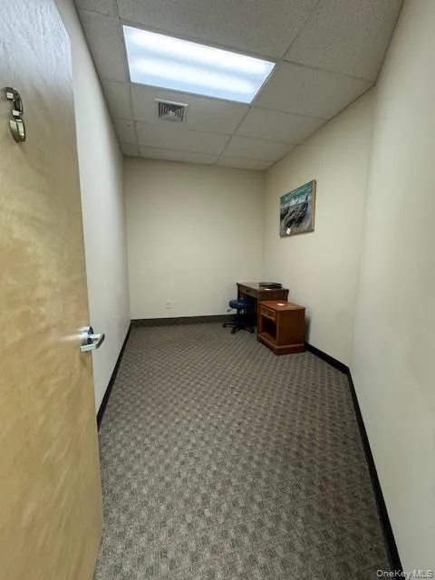 Unfurnished office with carpet floors and a drop ceiling Unfurnished office with carpet floors and a drop ceiling