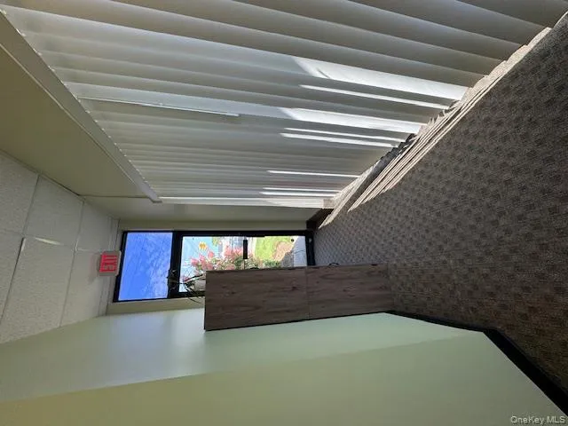 Hall with dark colored carpet and a paneled ceiling Hall with dark colored carpet and a paneled ceiling