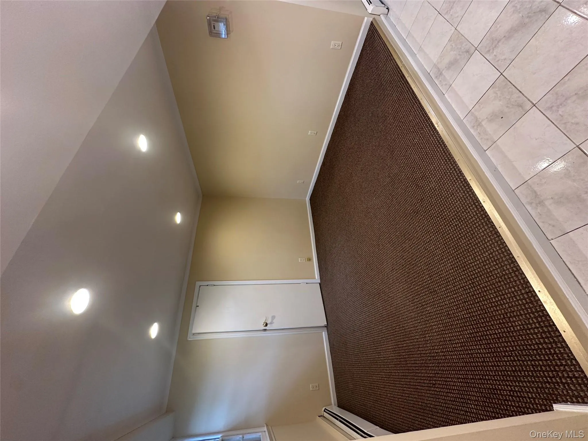 Spare room with recessed lighting, baseboard heating, light carpet, crown molding, and light tile patterned floors Spare room with recessed lighting, baseboard heating, light carpet, crown molding, and light tile patterned floors