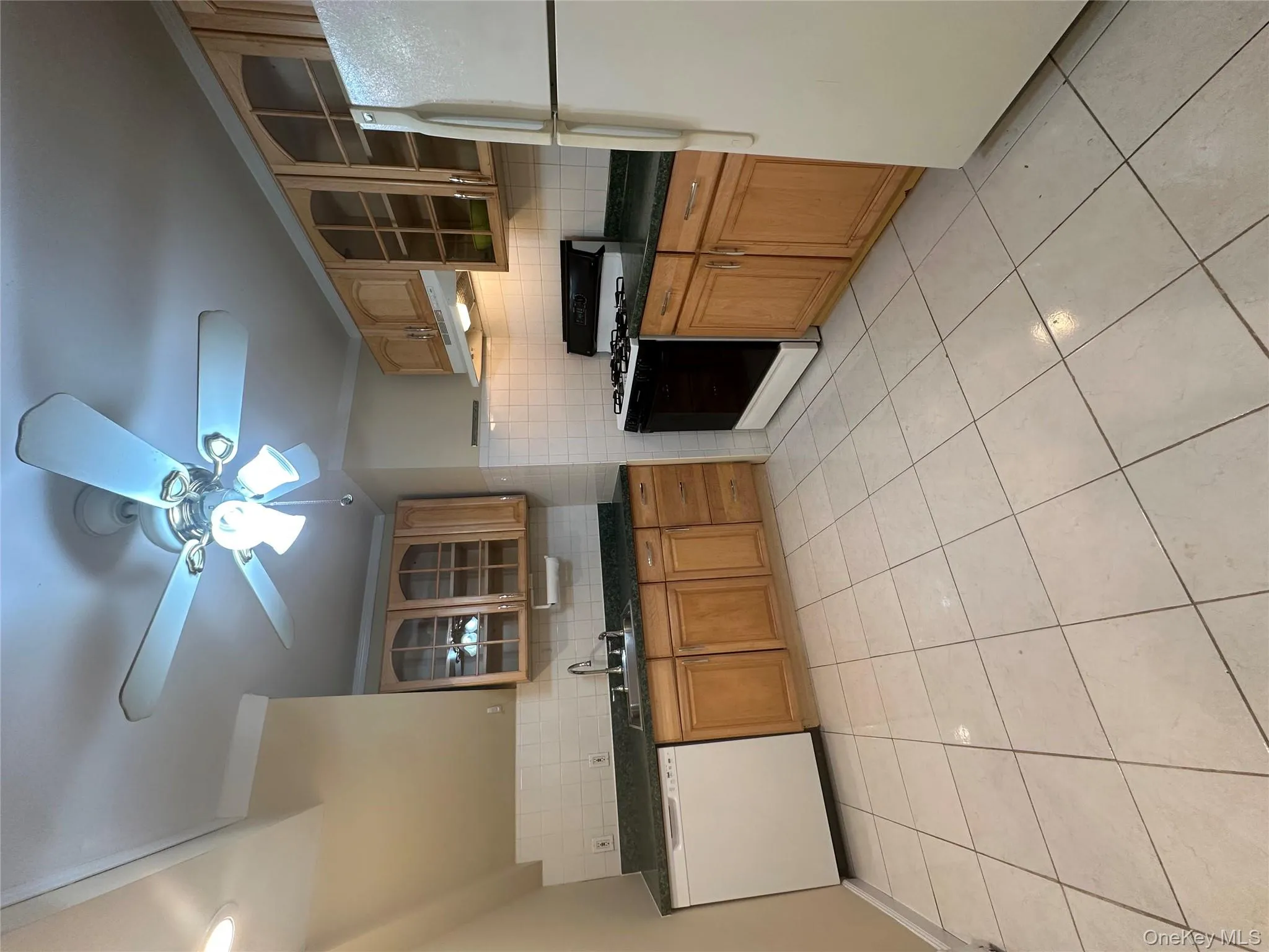 Kitchen featuring glass insert cabinets, backsplash, stove, refrigerator, and ornamental molding Kitchen featuring glass insert cabinets, backsplash, stove, refrigerator, and ornamental molding