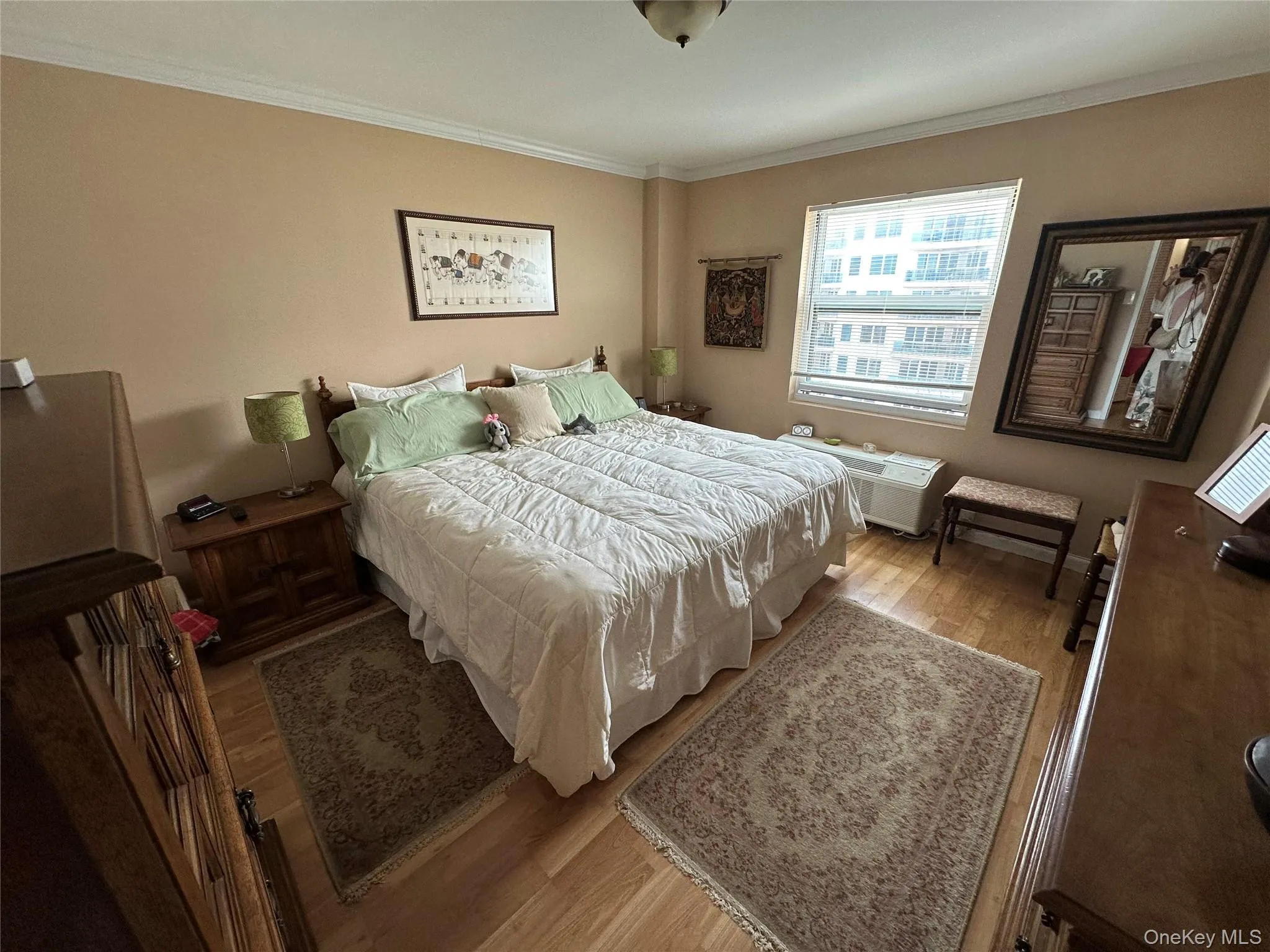 Bedroom featuring crown molding and wood finished floors Bedroom featuring crown molding and wood finished floors