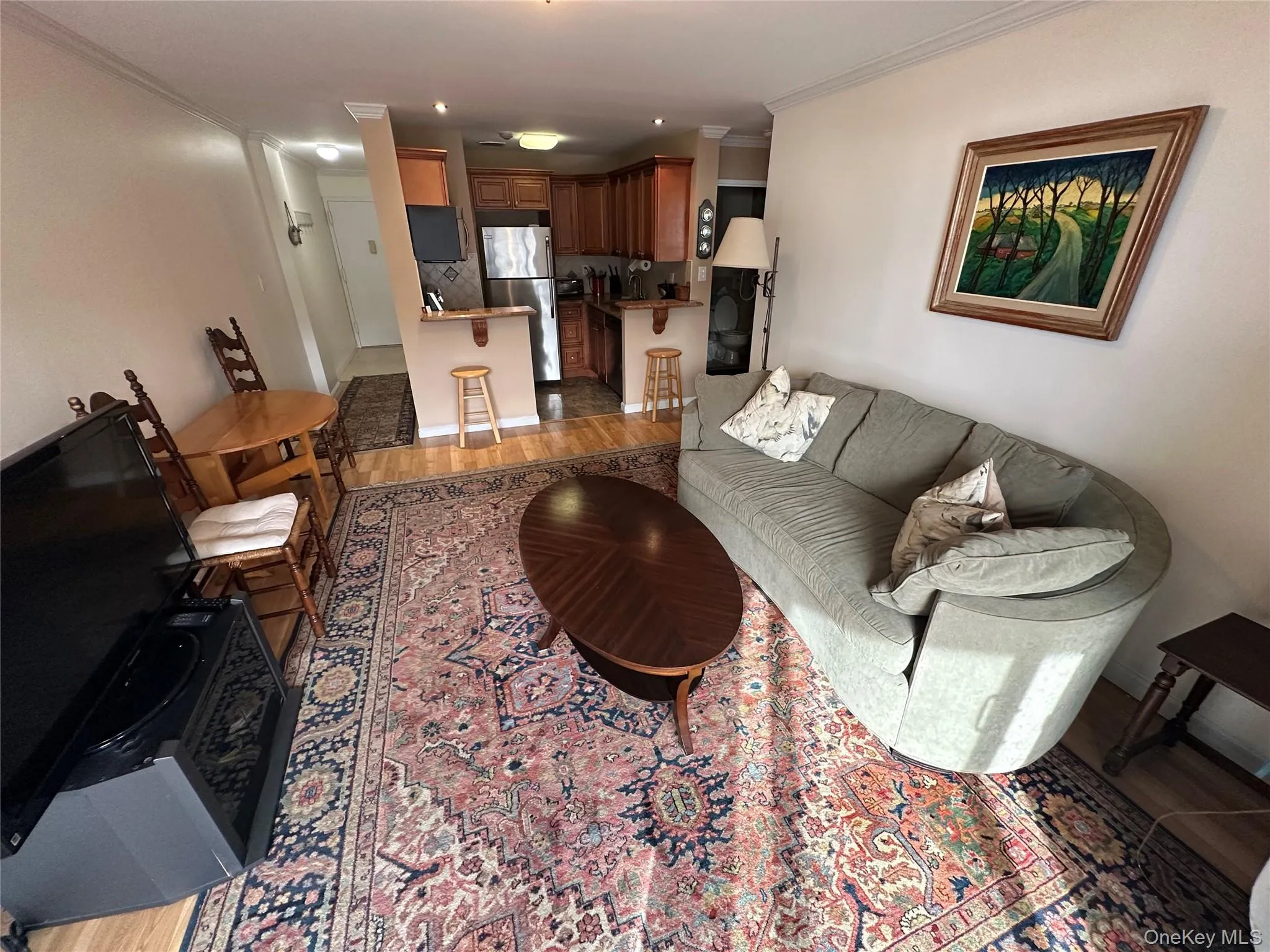 Living room with light wood-style flooring and crown molding Living room with light wood-style flooring and crown molding