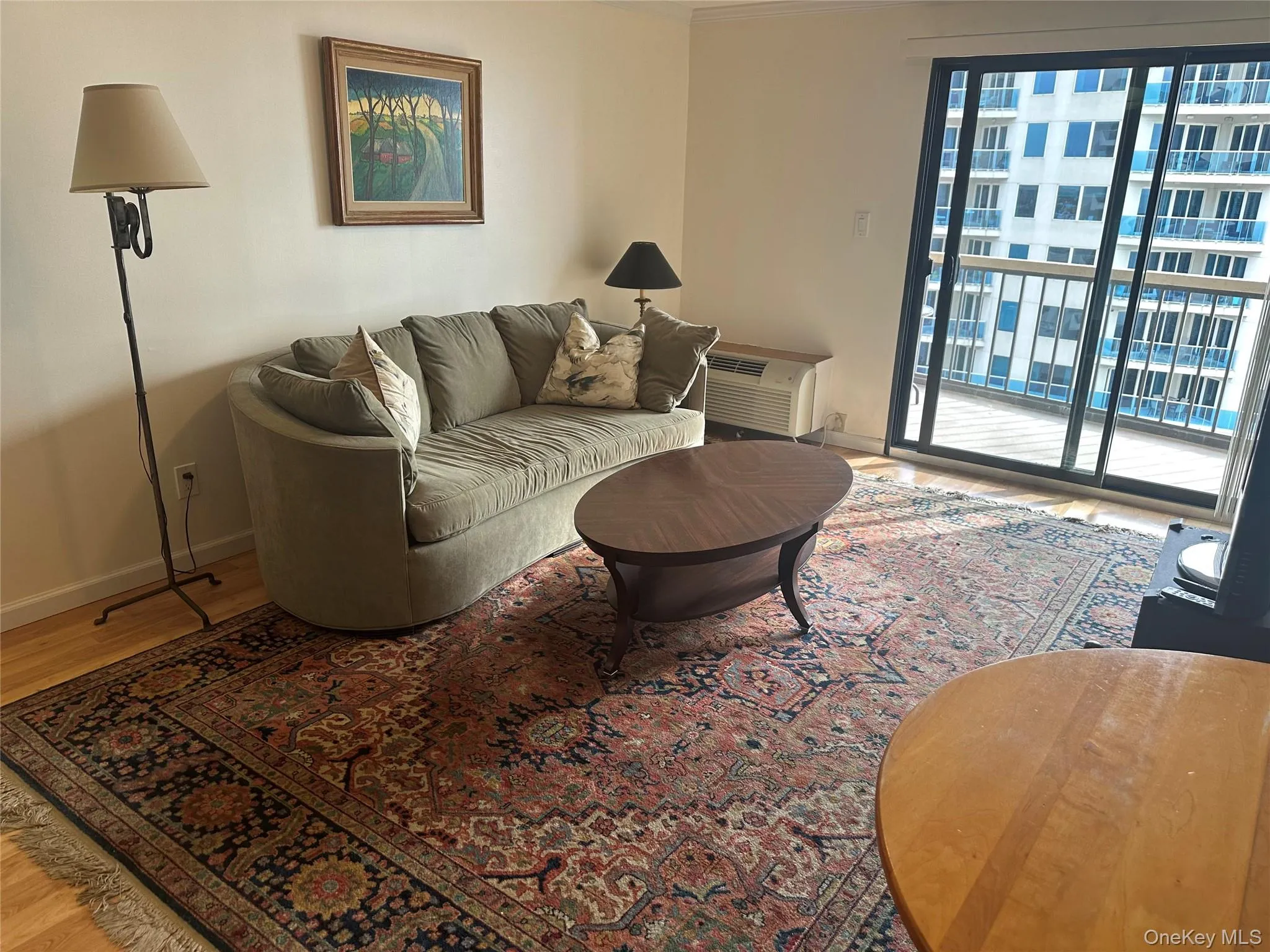 Living room with light wood-style flooring and a wall unit AC Living room with light wood-style flooring and a wall unit AC