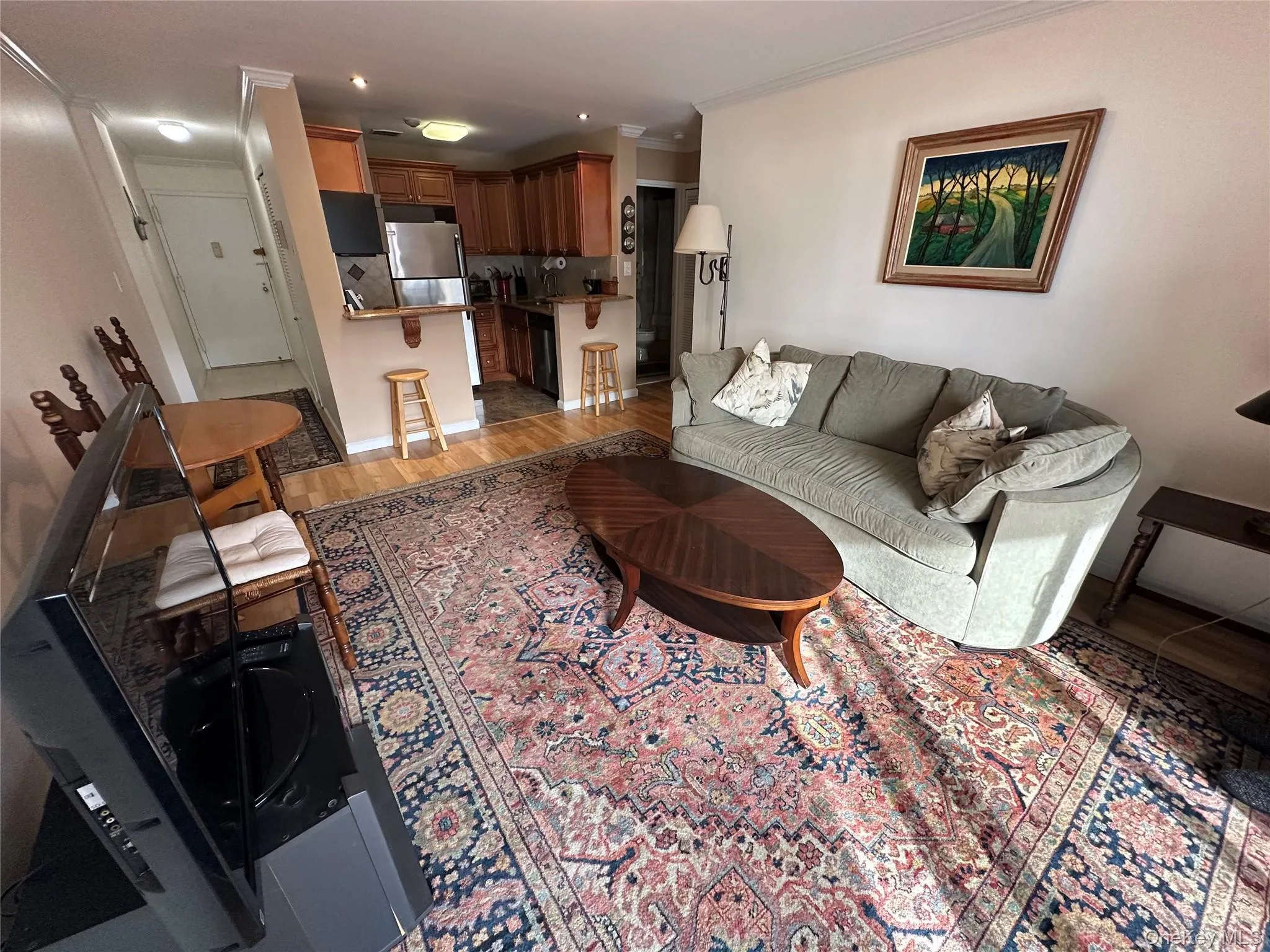 Living area featuring light wood-style flooring, crown molding, and recessed lighting Living area featuring light wood-style flooring, crown molding, and recessed lighting