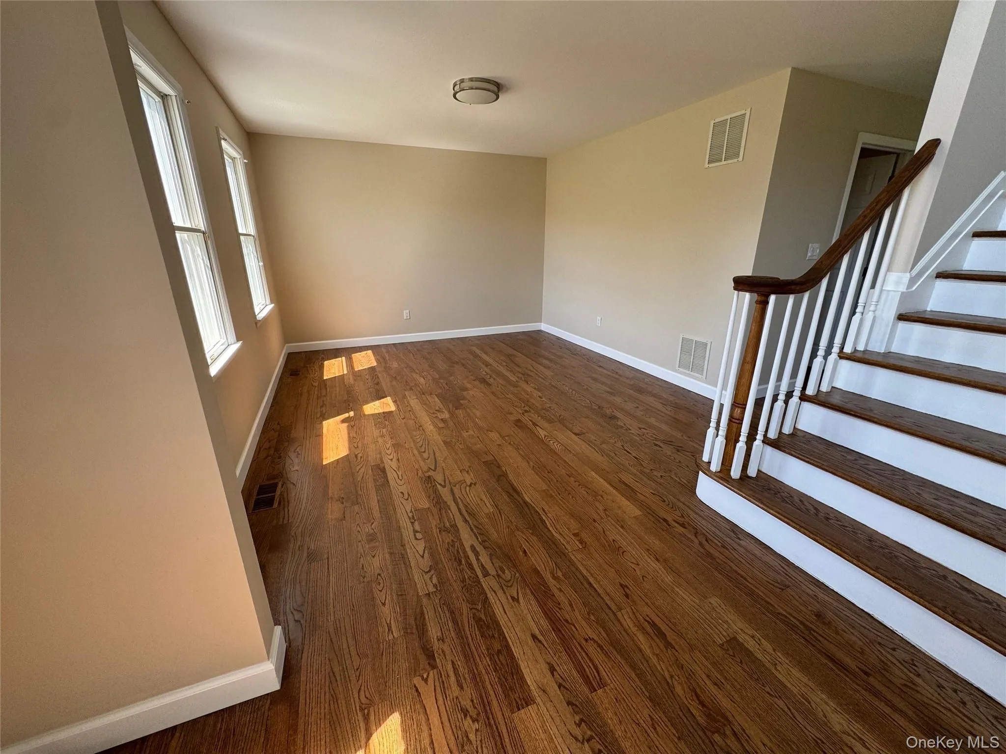 Hardwood flooring throughout the main living area, featuring multiple windows. Hardwood flooring throughout the main living area, featuring multiple windows.