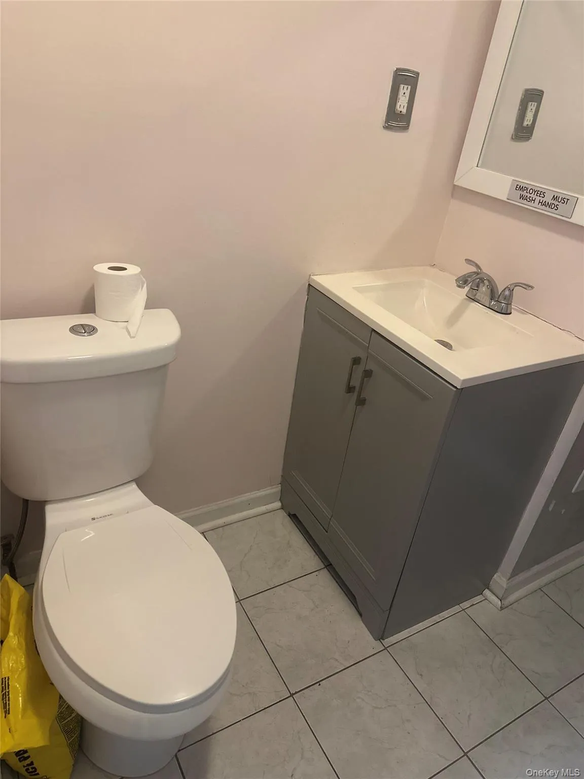 Half bathroom with vanity and light tile patterned flooring Half bathroom with vanity and light tile patterned flooring