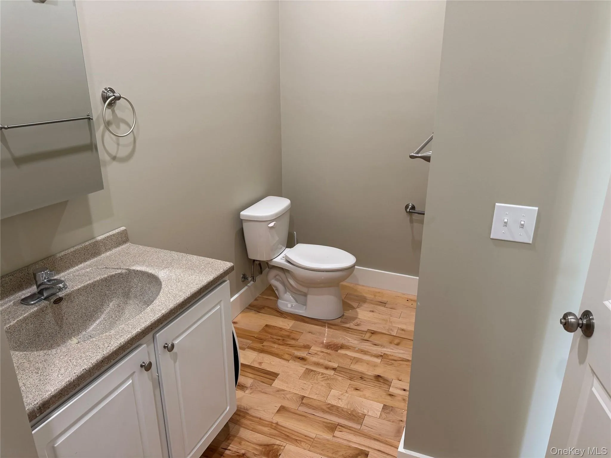 Half bathroom featuring vanity and light wood-style floors Half bathroom featuring vanity and light wood-style floors
