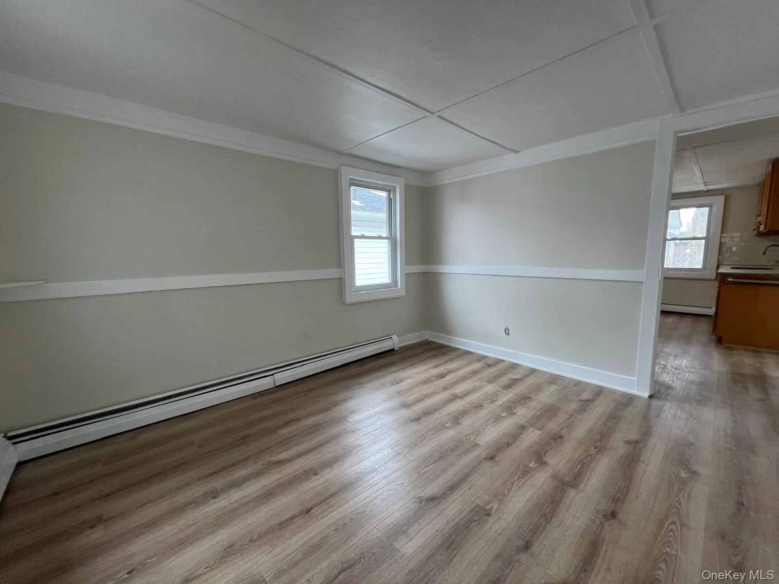 Unfurnished room with a baseboard heating unit and light wood-type flooring Unfurnished room with a baseboard heating unit and light wood-type flooring