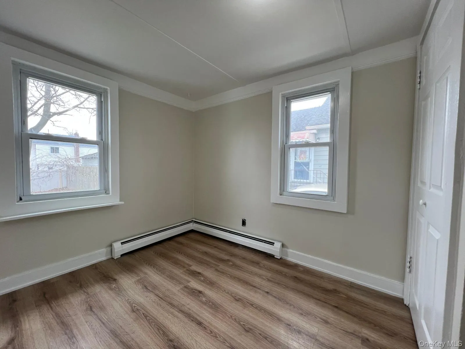 Empty room featuring light wood-style floors and baseboard heating Empty room featuring light wood-style floors and baseboard heating