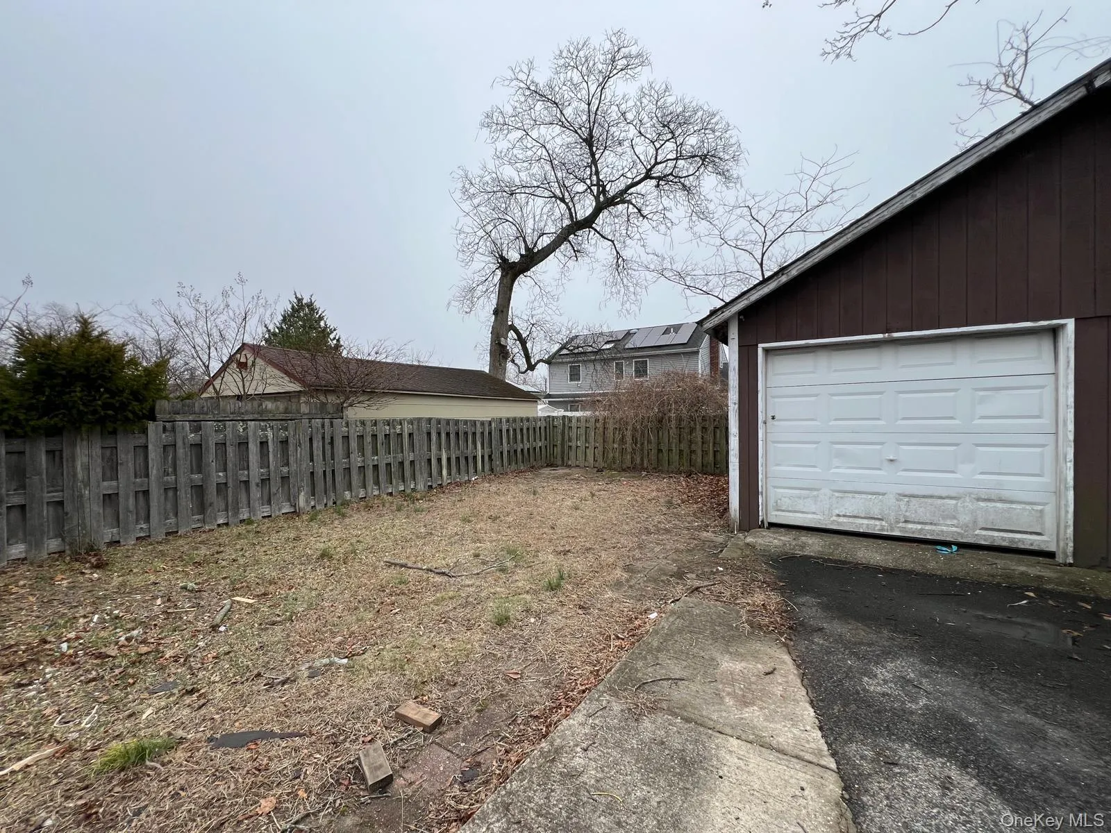 View of yard featuring a garage and an outbuilding View of yard featuring a garage and an outbuilding