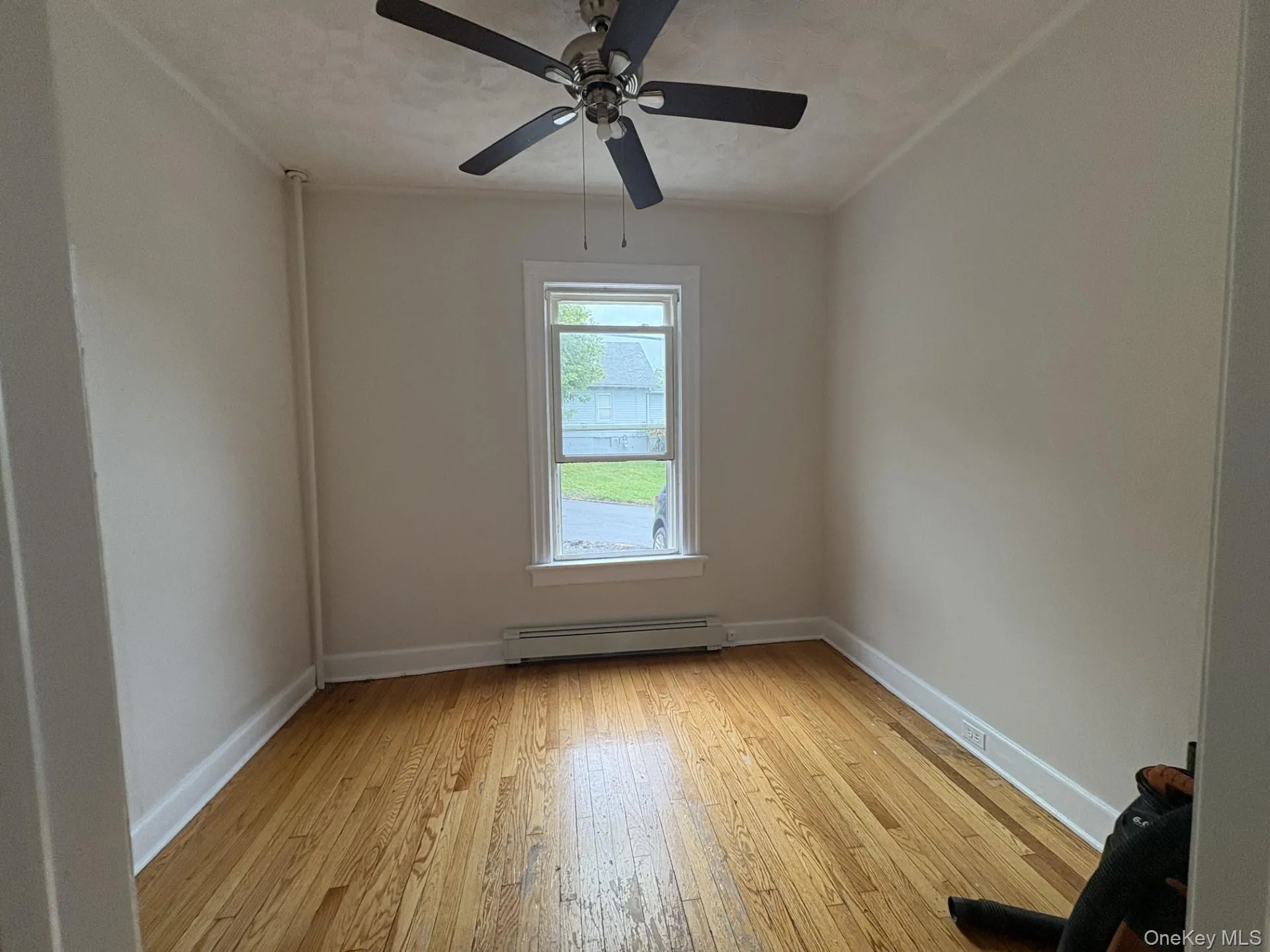 Spare room with light wood-style flooring and a baseboard radiator Spare room with light wood-style flooring and a baseboard radiator
