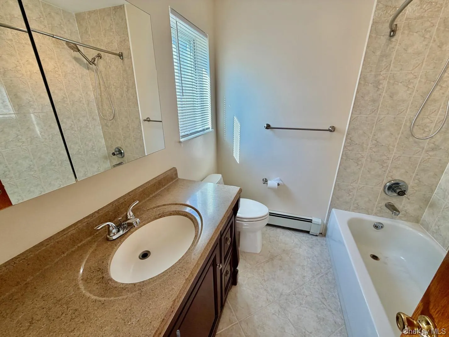 Full bath featuring shower / bathtub combination, baseboard heating, vanity, and light tile patterned flooring Full bath featuring shower / bathtub combination, baseboard heating, vanity, and light tile patterned flooring