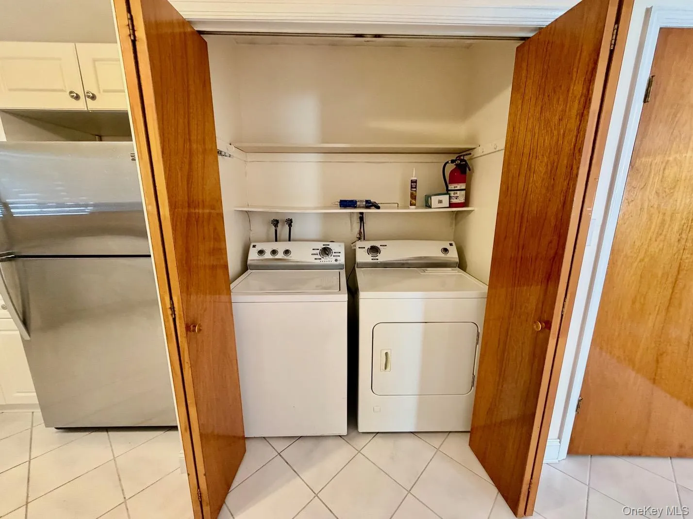 Laundry room featuring light tile patterned floors and washing machine and dryer Laundry room featuring light tile patterned floors and washing machine and dryer