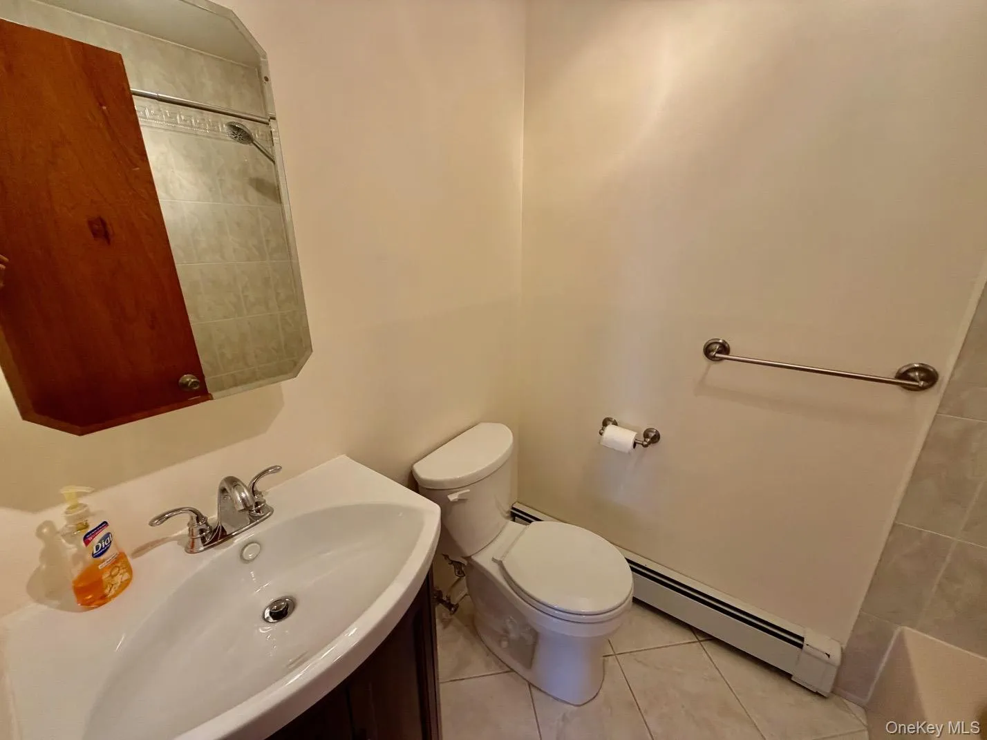 Full bath featuring a baseboard heating unit, vanity, light tile patterned floors, and a bathtub Full bath featuring a baseboard heating unit, vanity, light tile patterned floors, and a bathtub