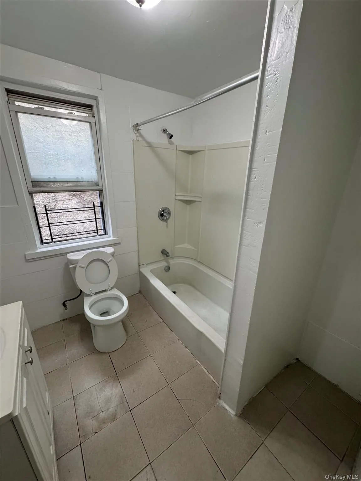 Bathroom with tub / shower combination, vanity, and light tile patterned floors Bathroom with tub / shower combination, vanity, and light tile patterned floors