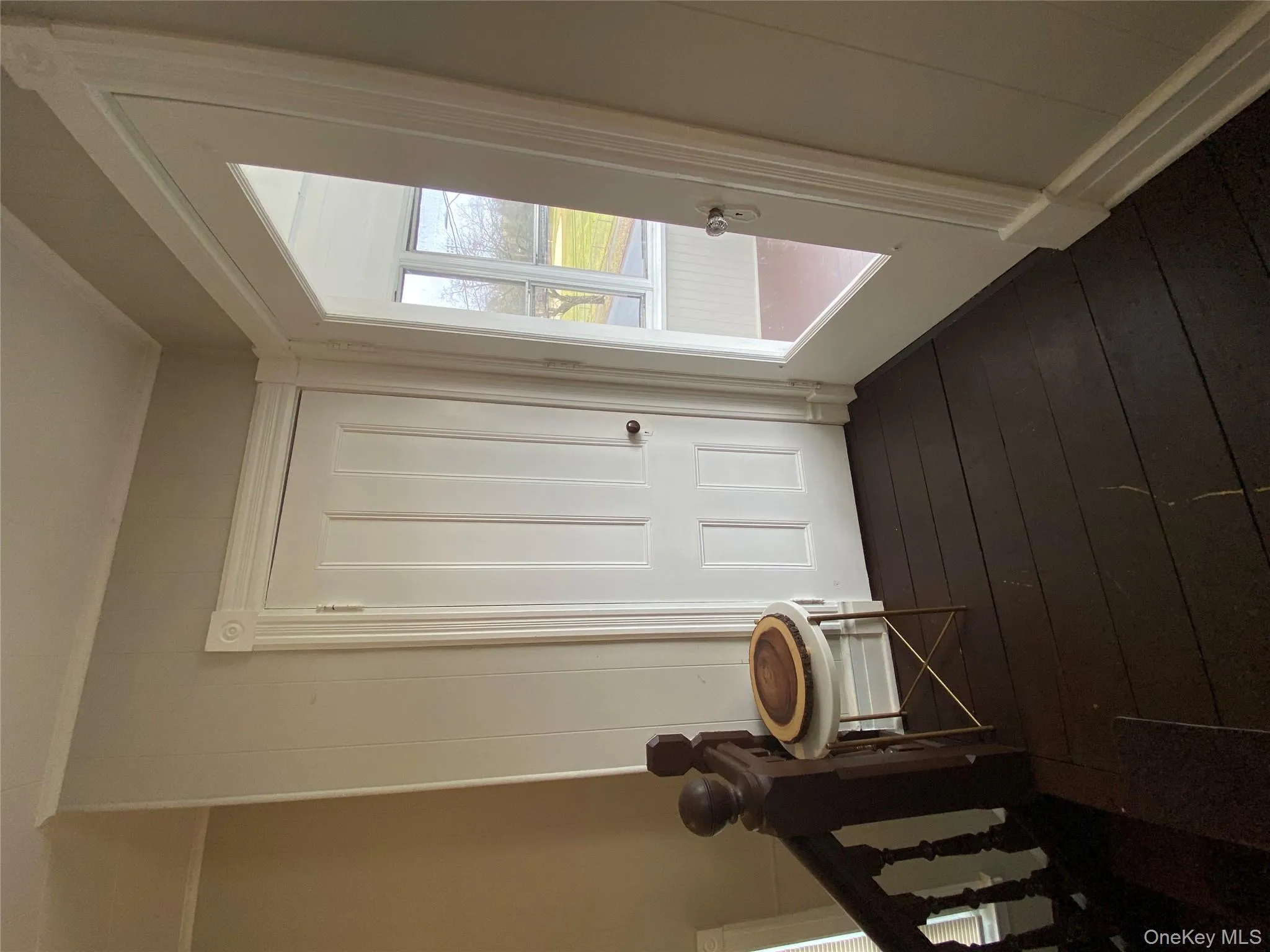 Hallway featuring dark wood-style flooring and crown molding Hallway featuring dark wood-style flooring and crown molding