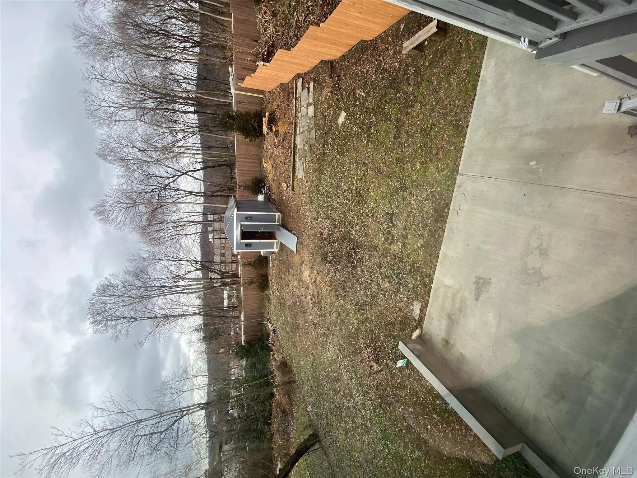 Fenced backyard with an outdoor structure and a patio area Fenced backyard with an outdoor structure and a patio area