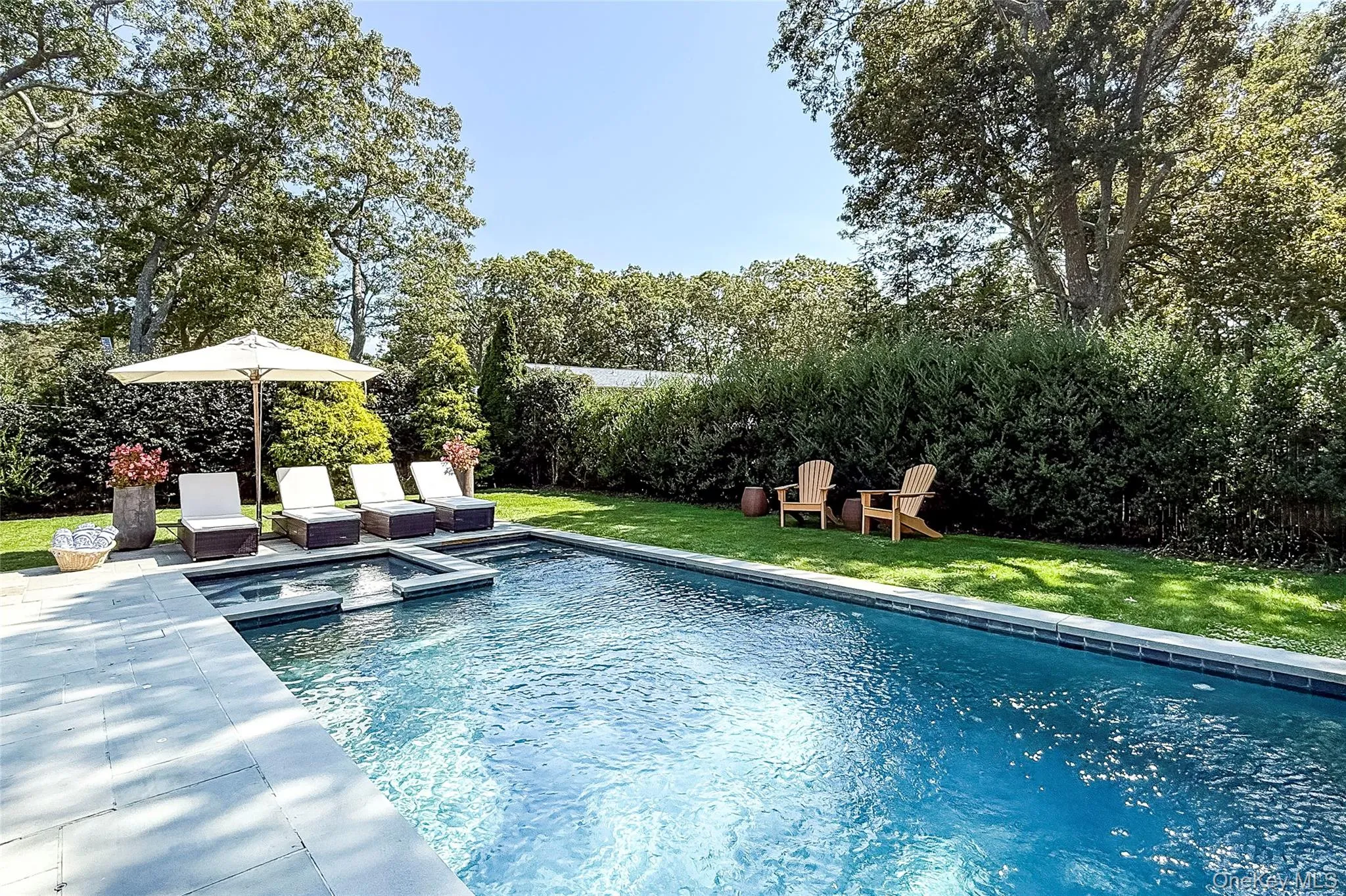 View of pool featuring a yard, a patio area, a pool with connected hot tub, and view of scattered trees View of pool featuring a yard, a patio area, a pool with connected hot tub, and view of scattered trees