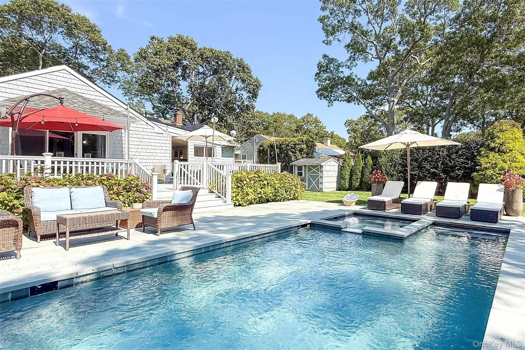 View of pool featuring a patio area, a pool with connected hot tub, an outdoor living space, and a storage unit View of pool featuring a patio area, a pool with connected hot tub, an outdoor living space, and a storage unit