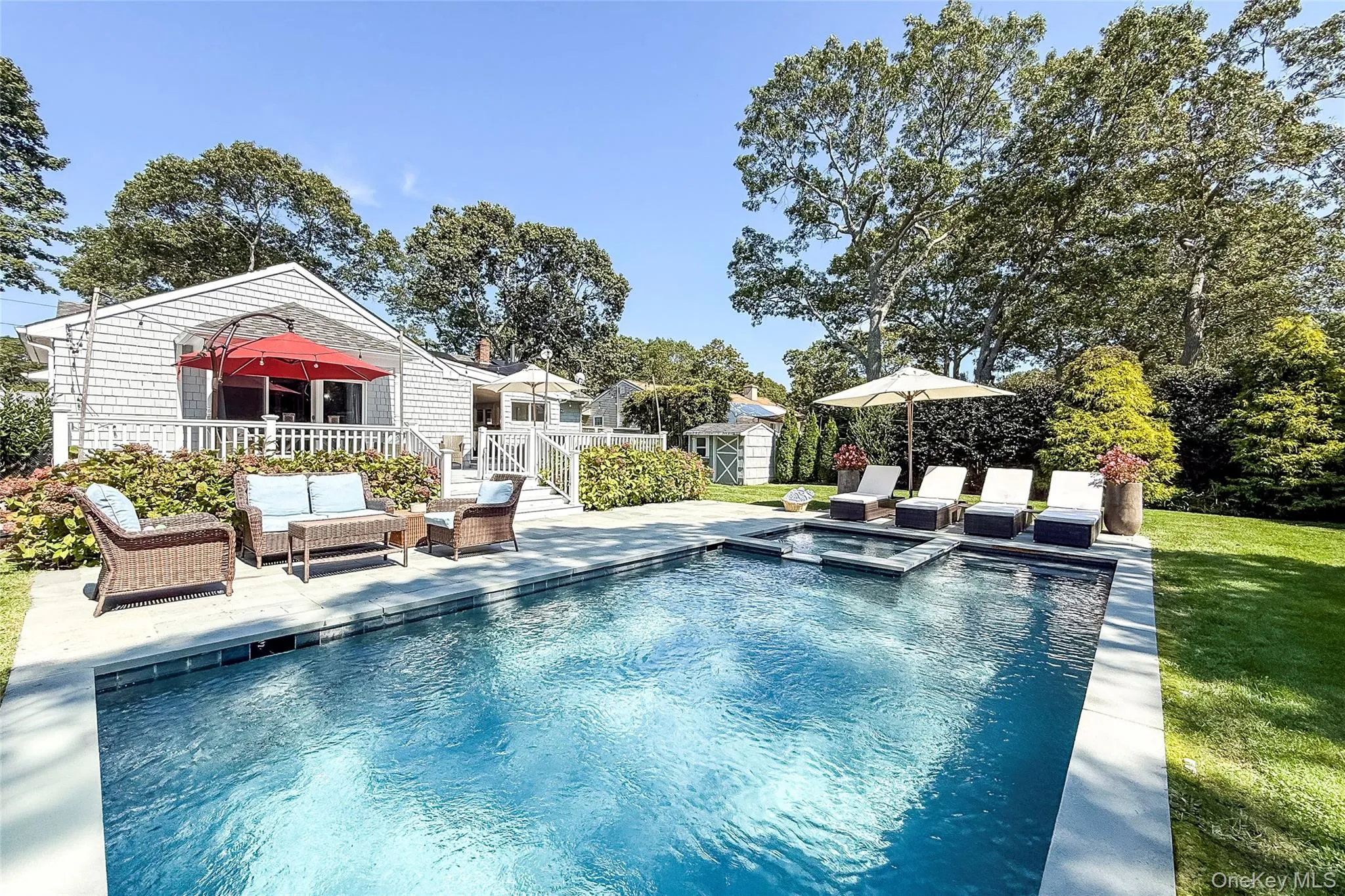 View of pool featuring a patio area, a pool with connected hot tub, an outdoor living space, and a storage unit View of pool featuring a patio area, a pool with connected hot tub, an outdoor living space, and a storage unit