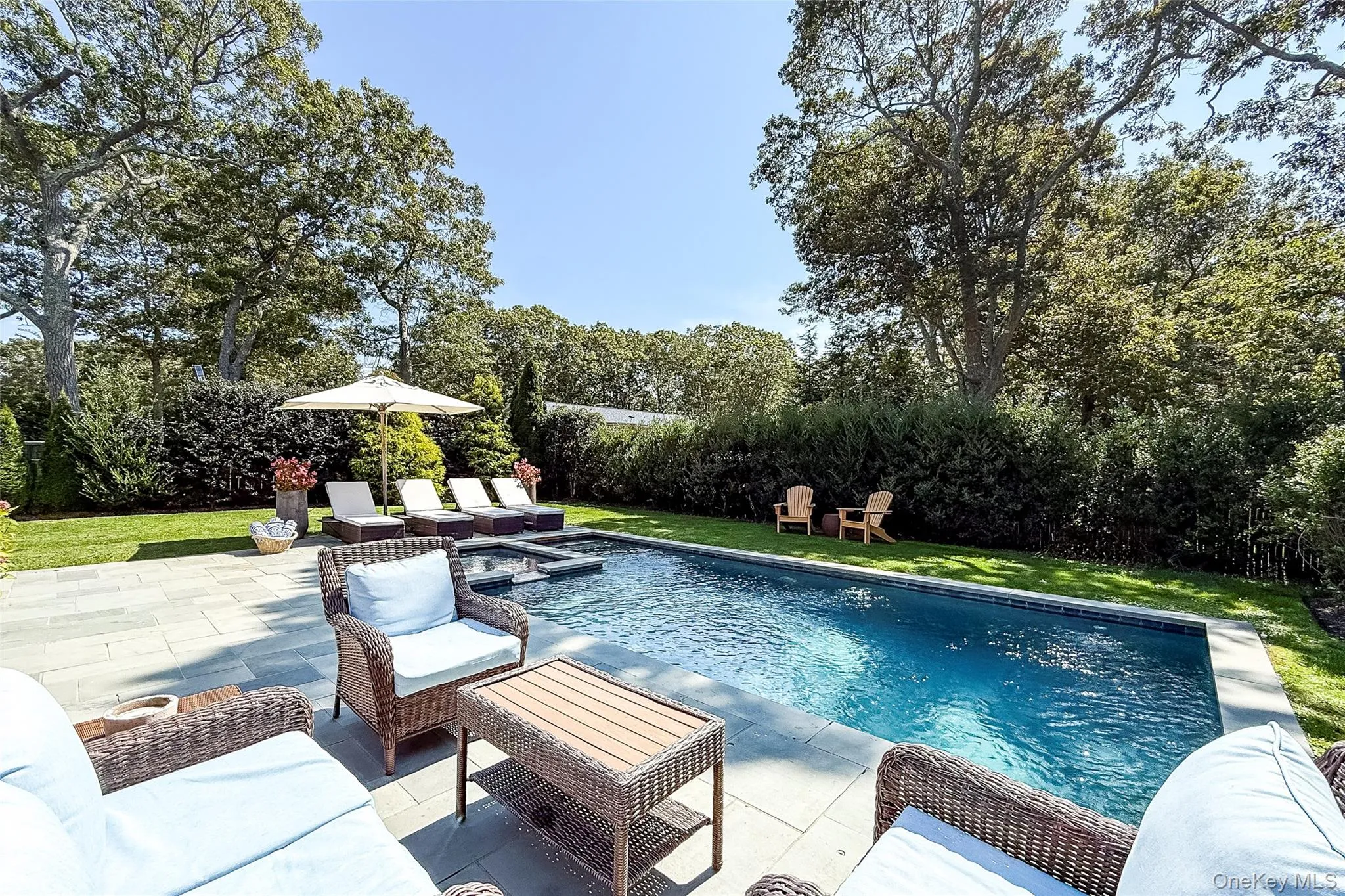 Outdoor pool with a lawn, an outdoor living space, a patio, and view of wooded area Outdoor pool with a lawn, an outdoor living space, a patio, and view of wooded area