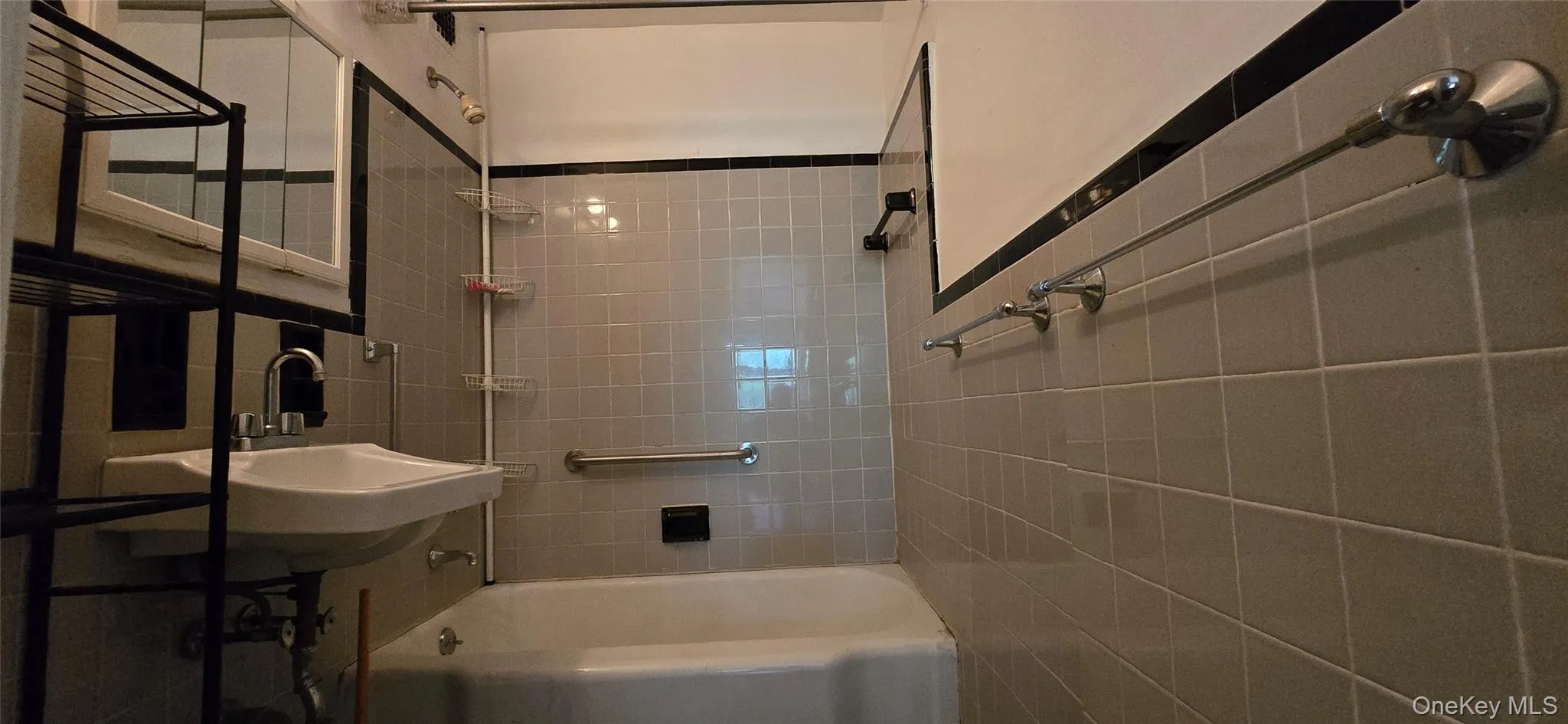 Full bath featuring shower / bathtub combination and tile walls Full bath featuring shower / bathtub combination and tile walls