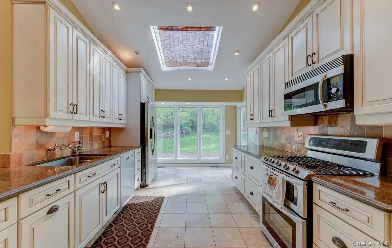Kitchen featuring stainless steel appliances, dark stone counters, tasteful backsplash, recessed lighting, and light tile patterned flooring Kitchen featuring stainless steel appliances, dark stone counters, tasteful backsplash, recessed lighting, and light tile patterned flooring