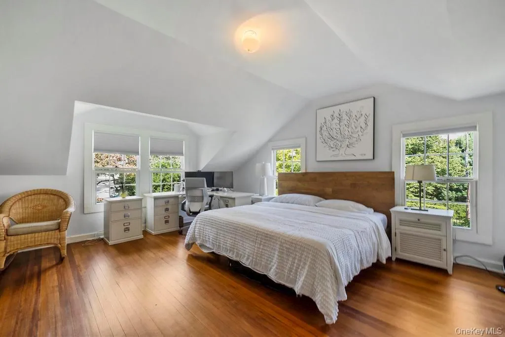 Bedroom with lofted ceiling, hardwood / wood-style floors, and a desk Bedroom with lofted ceiling, hardwood / wood-style floors, and a desk