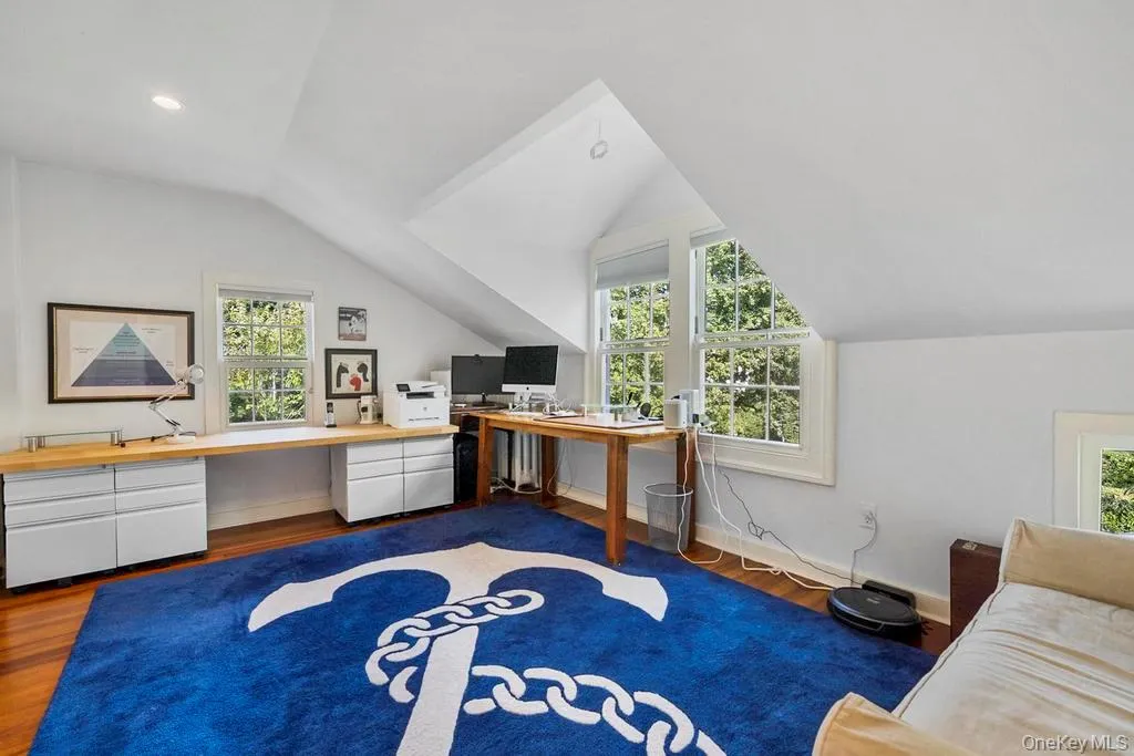 Office space with dark wood-style flooring, healthy amount of natural light, and vaulted ceiling Office space with dark wood-style flooring, healthy amount of natural light, and vaulted ceiling