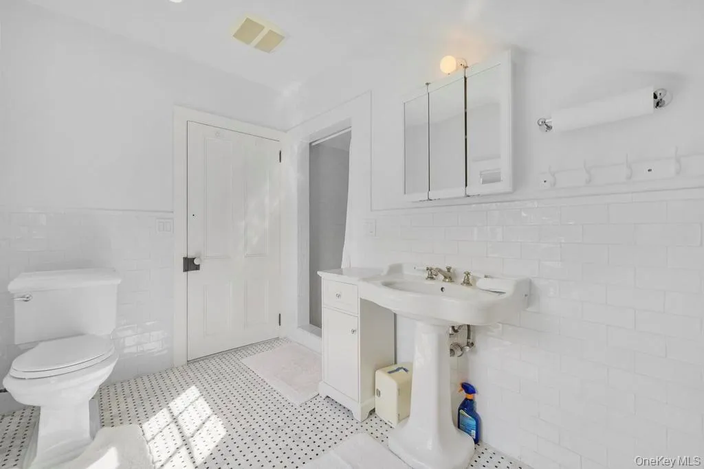 Bathroom with tile walls, a wainscoted wall, and a shower stall Bathroom with tile walls, a wainscoted wall, and a shower stall