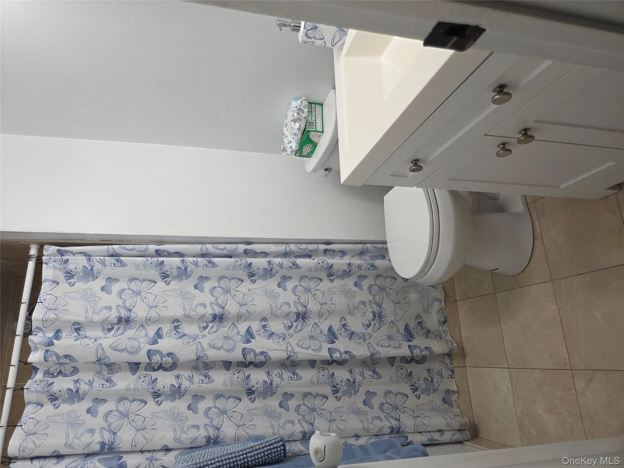Bathroom featuring vanity, light tile patterned floors, and curtained shower Bathroom featuring vanity, light tile patterned floors, and curtained shower
