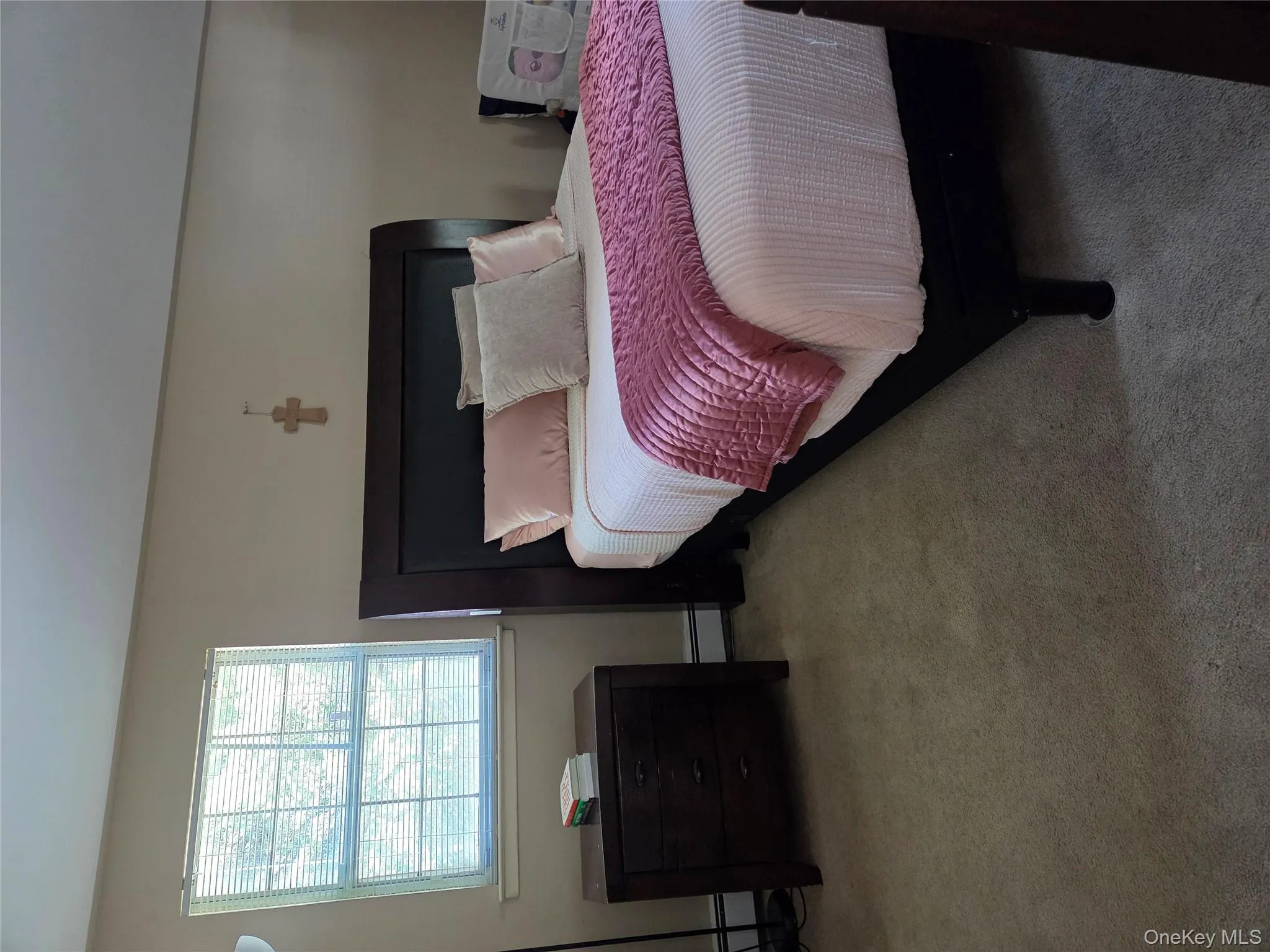Carpeted bedroom featuring a baseboard heating unit Carpeted bedroom featuring a baseboard heating unit