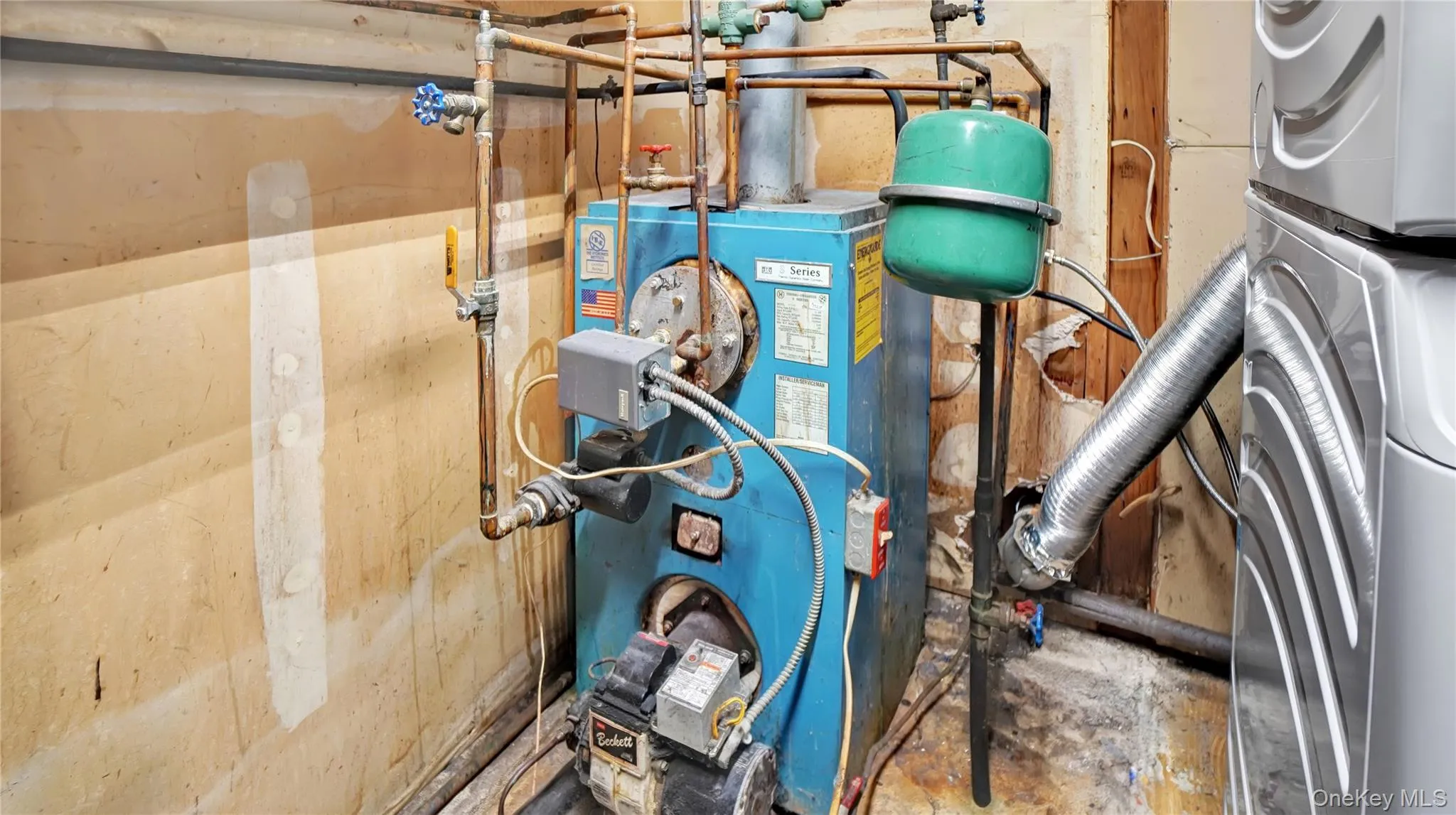 Utility room featuring a heating unit and stacked washer / drying machine Utility room featuring a heating unit and stacked washer / drying machine
