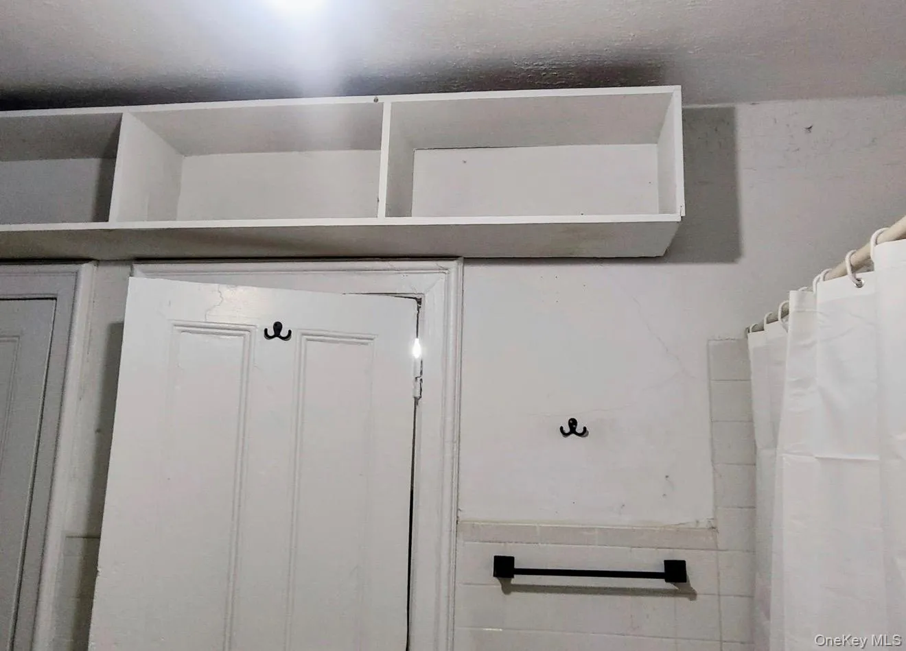 Bathroom view of a shower with shower curtain and a wainscoted wall Bathroom view of a shower with shower curtain and a wainscoted wall