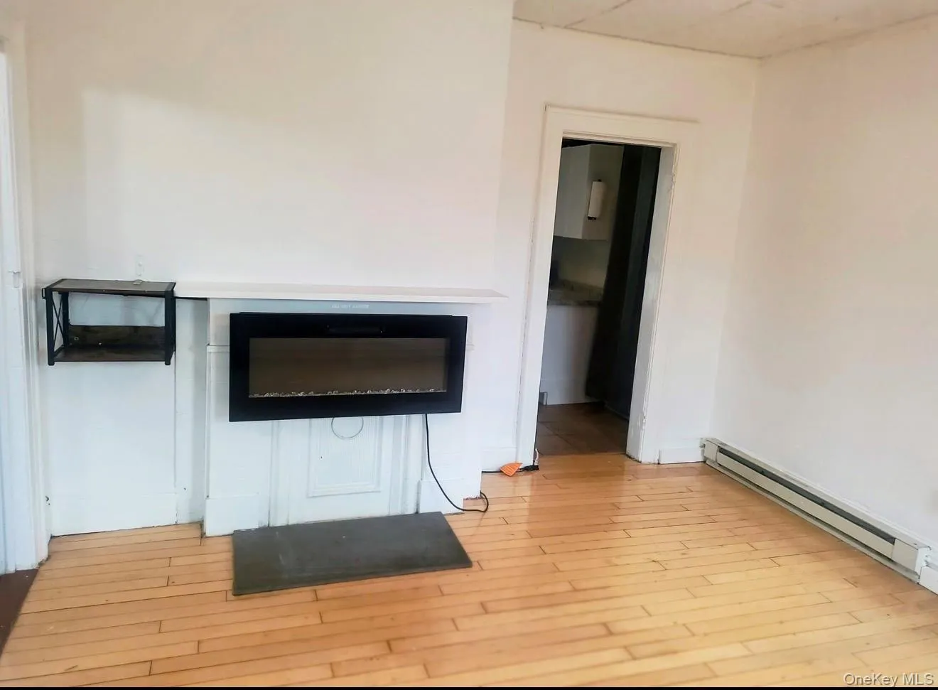 Detailed view of baseboard heating and wood finished floors Detailed view of baseboard heating and wood finished floors